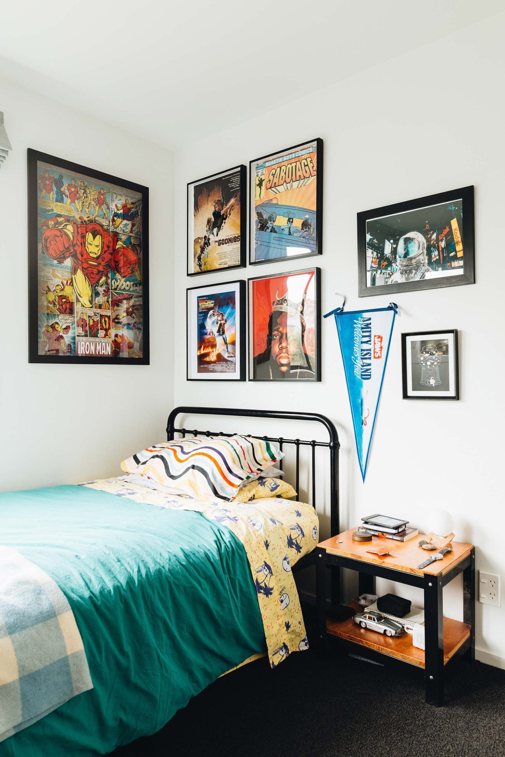 A boys' room with comic artwork on the all and blue and yellow bedding