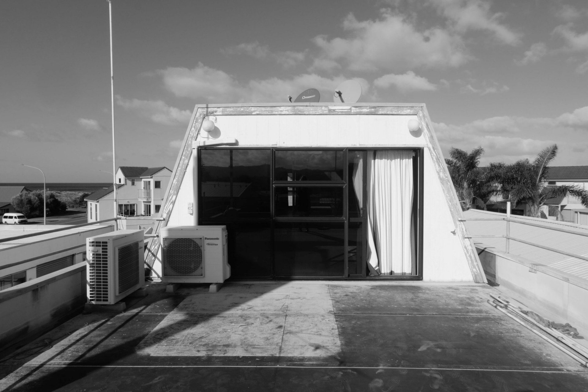 Black and white image of the exterior of the building, glass panels stick out from the top and the dairy below