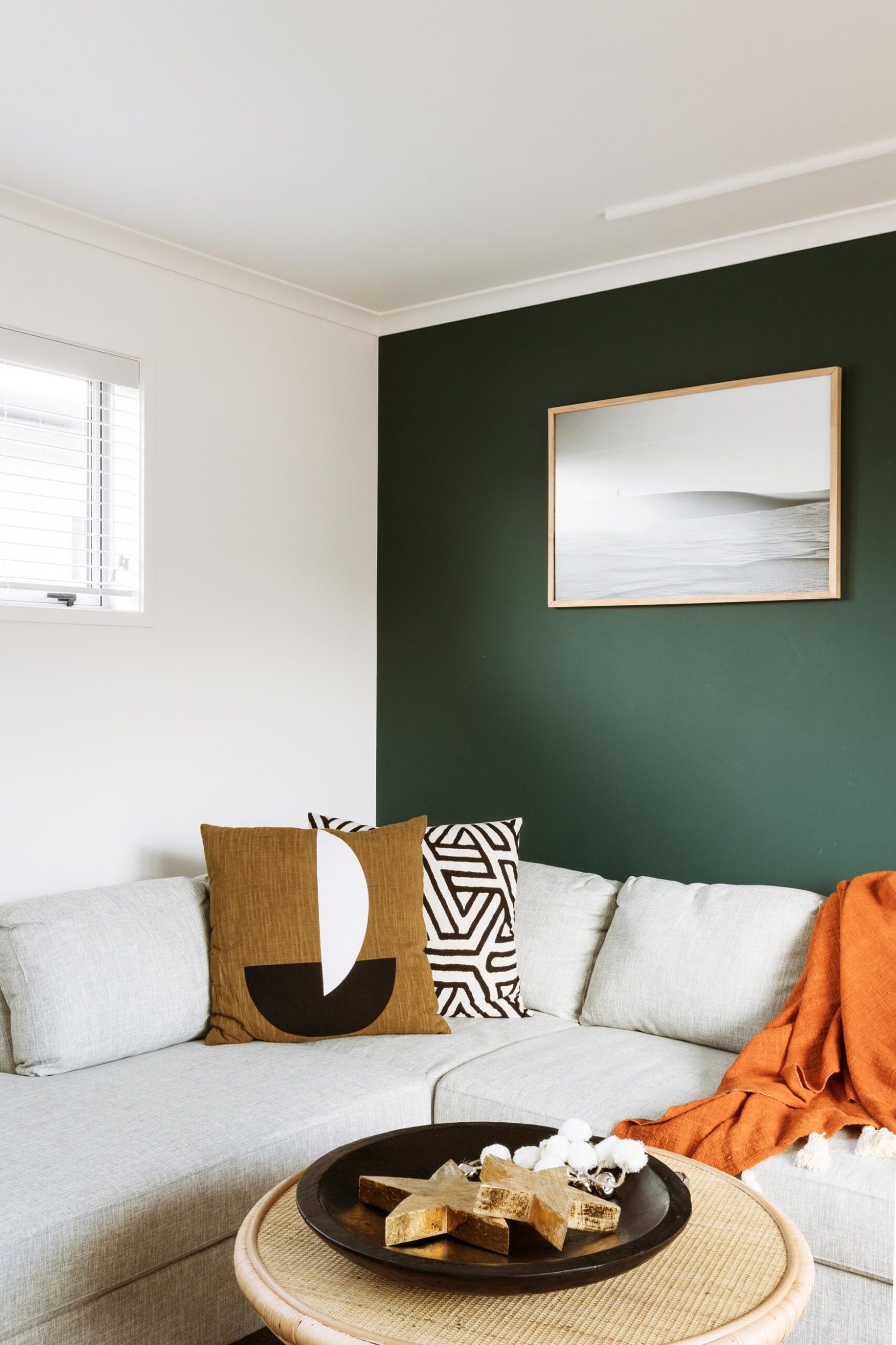 The same deep green is also used in the family room with a lighter beige sofa for cozy vibes