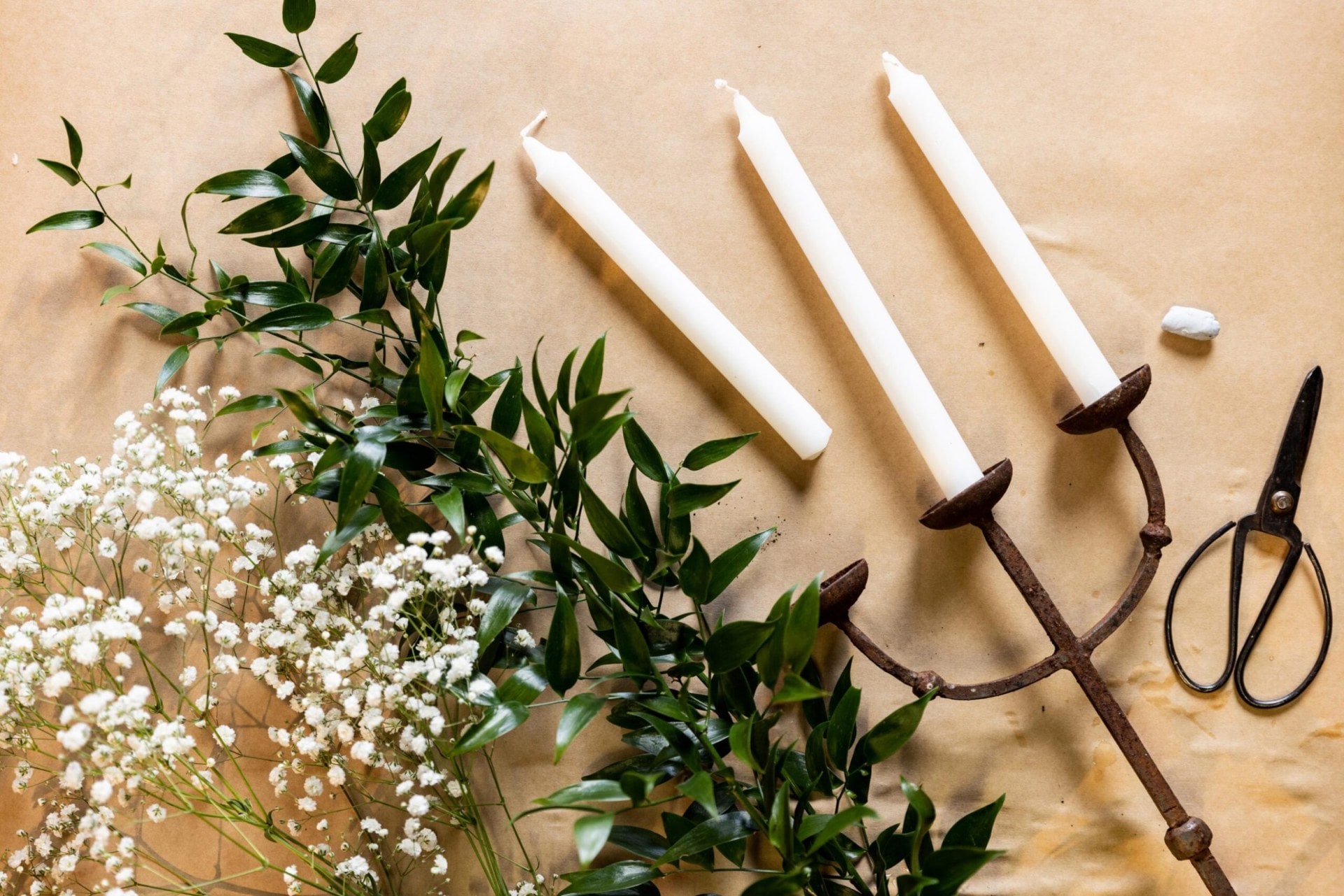 flowers and greenery, a candelabra and candles and scissors