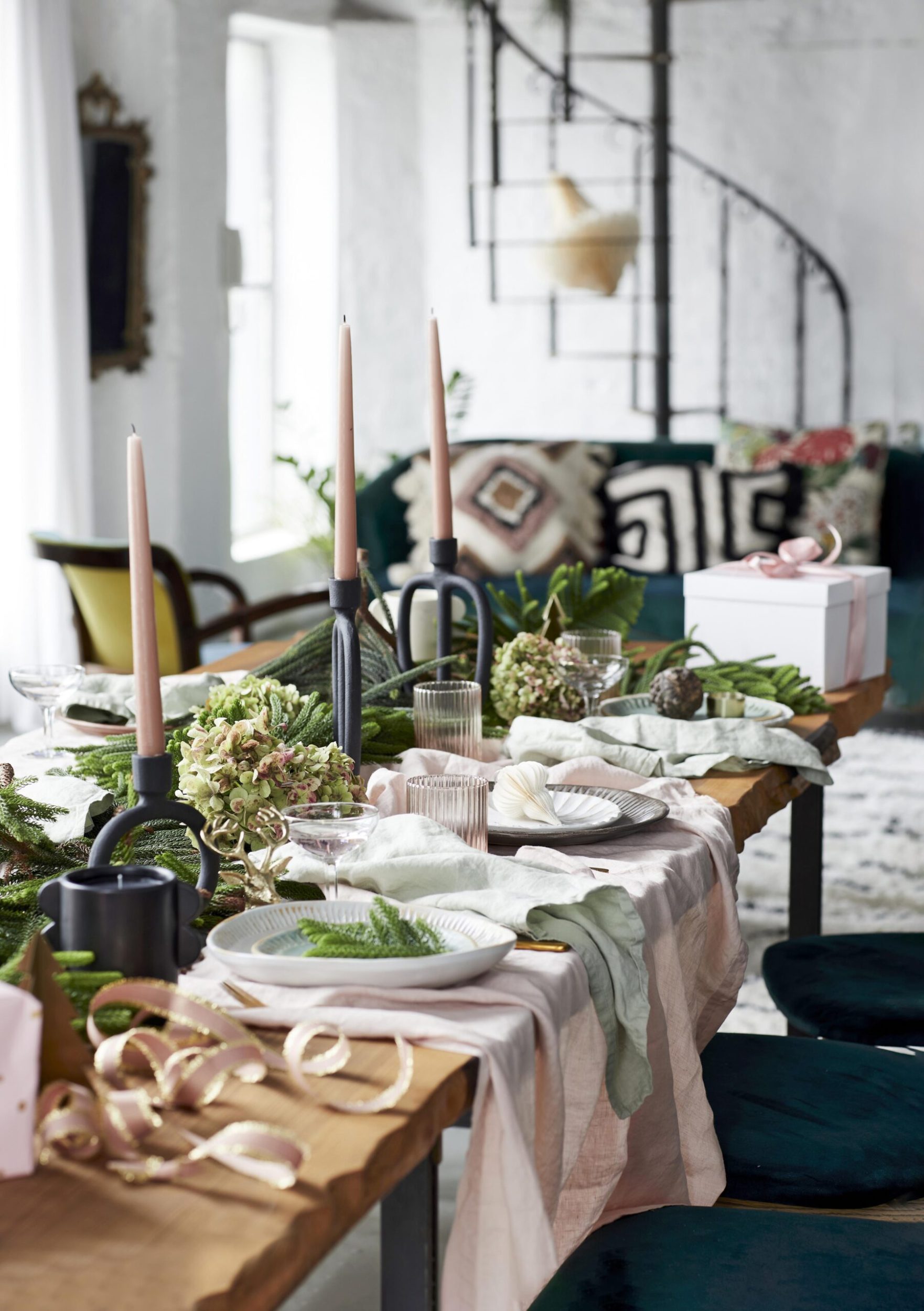 Full table setting with black candle holders with blush candles and a blush table cloth