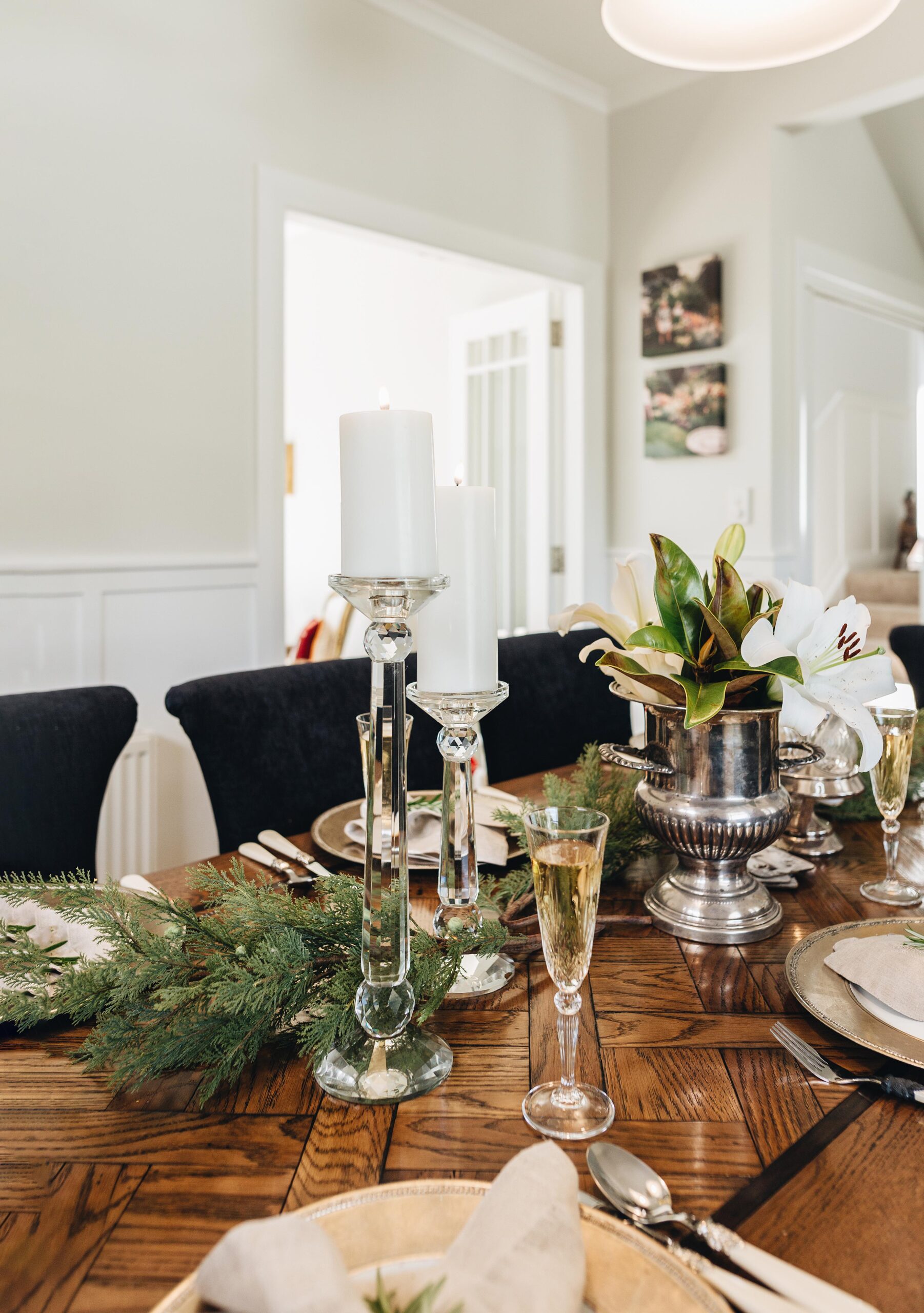 Dining table set with crystal candle holders, on a herringbone table with a garland through the middle