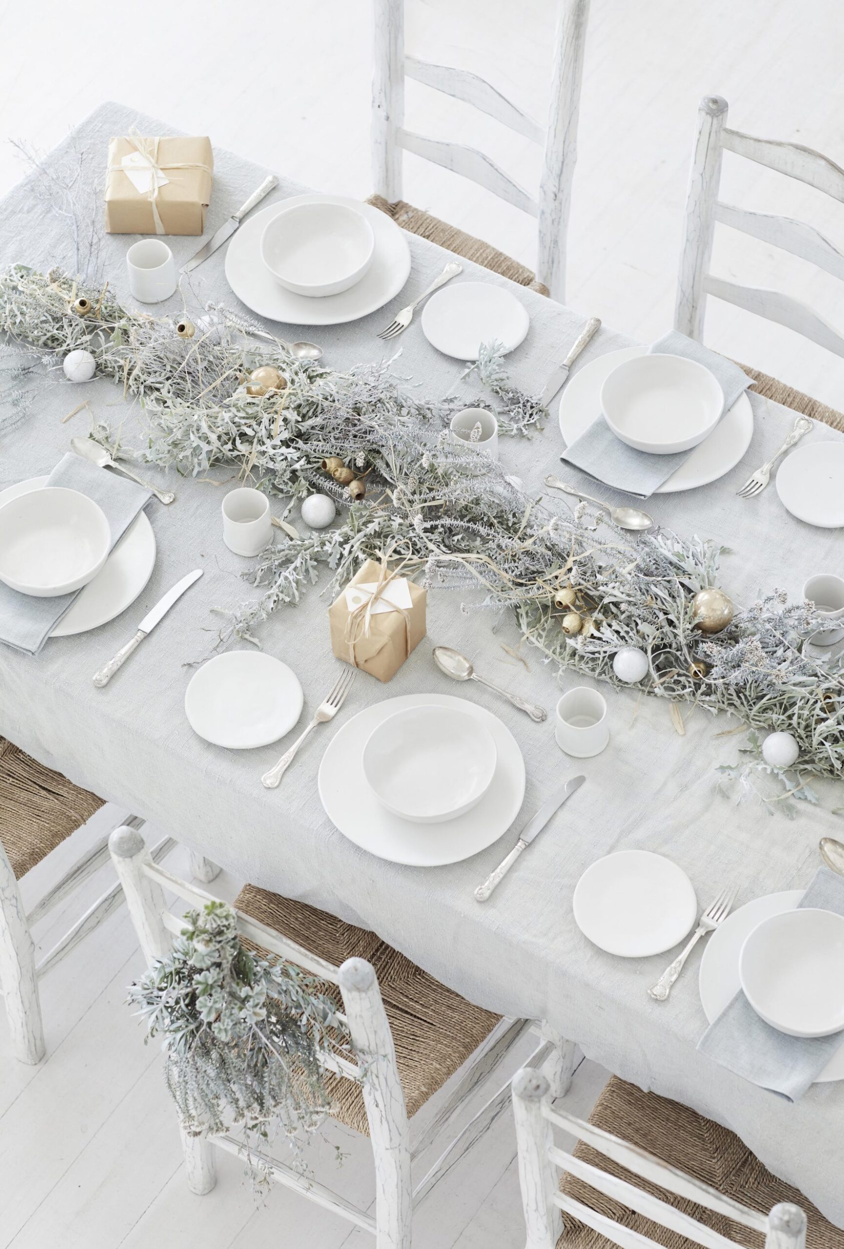 A table set with a grey table cloth and white plates