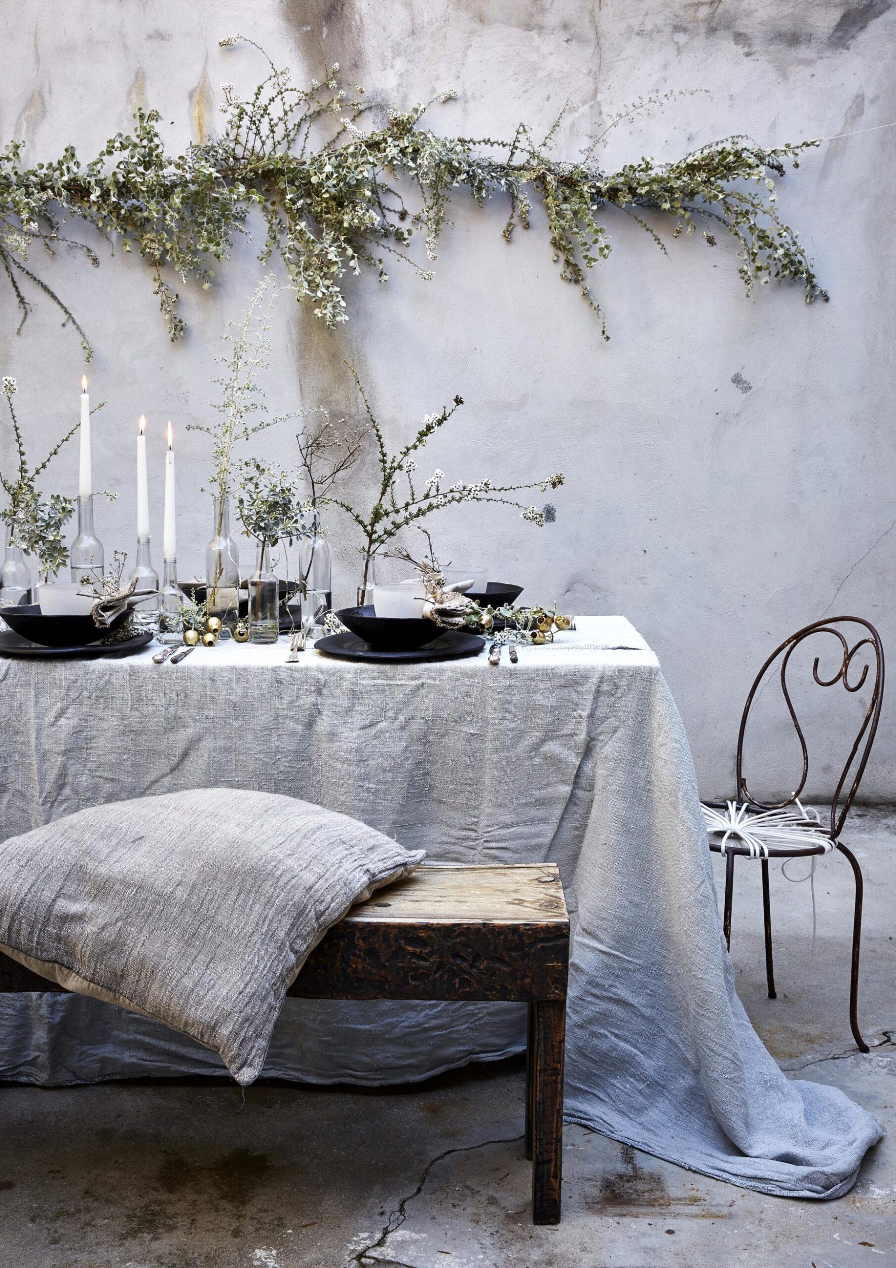 A metal table and chairs dressed for Christmas with a grey table cloth and cushion