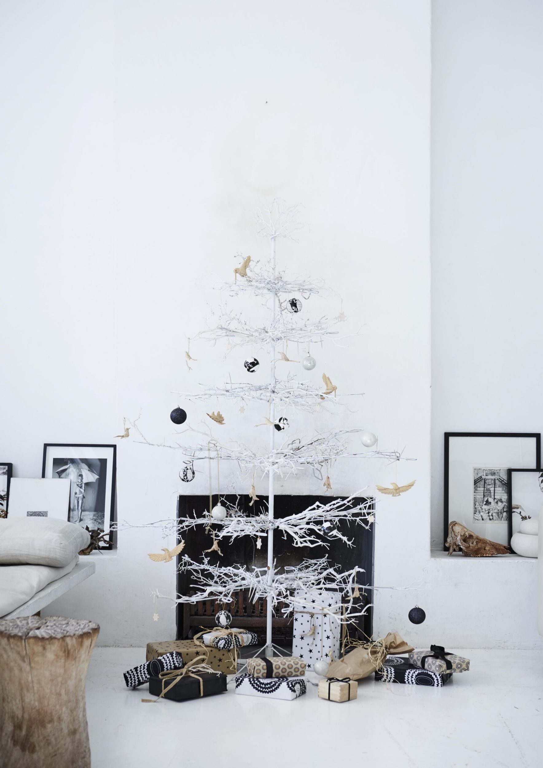 A bare white Christmas tree with black and gold decorations