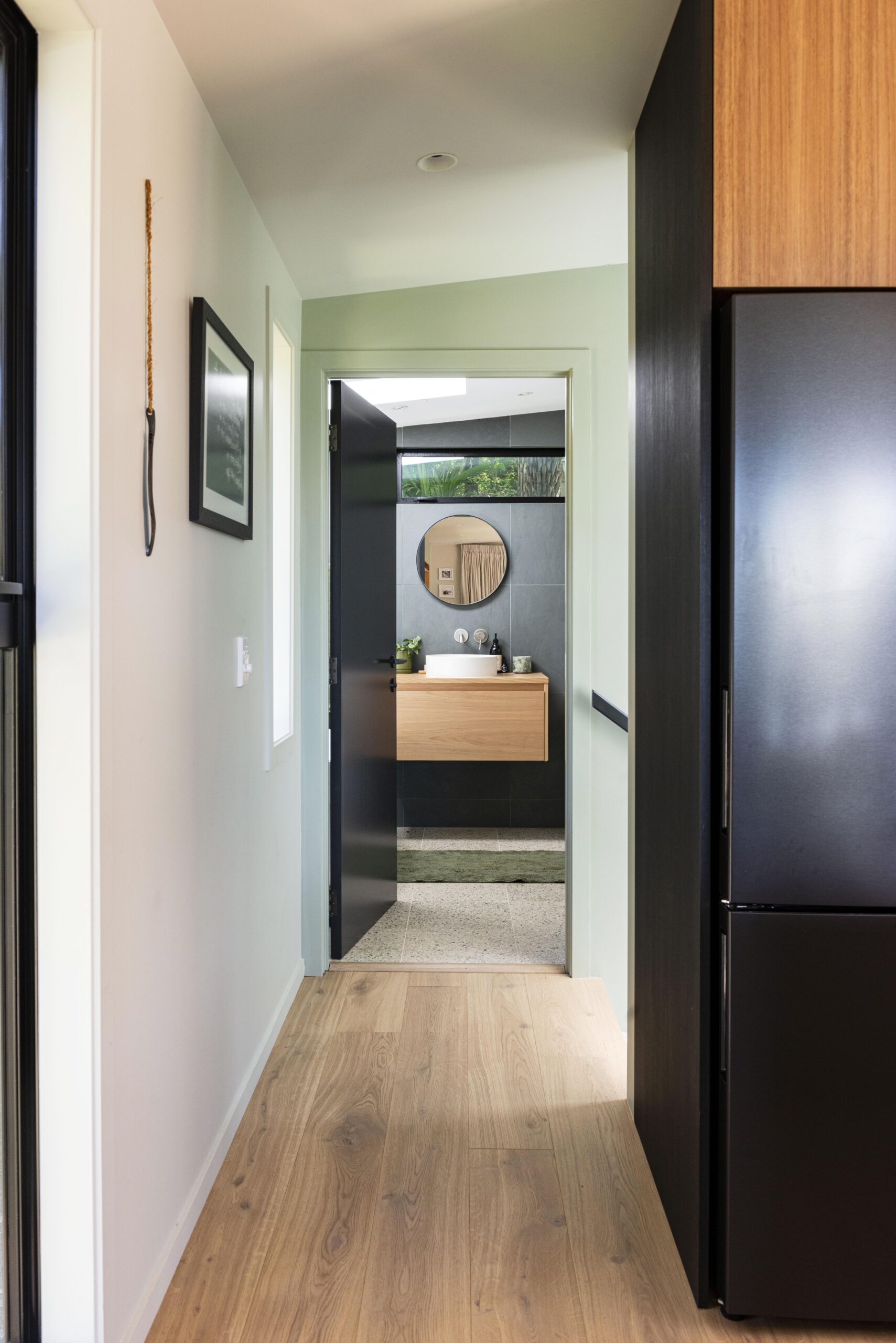 Oak floor in a hallway leading to a bathroom