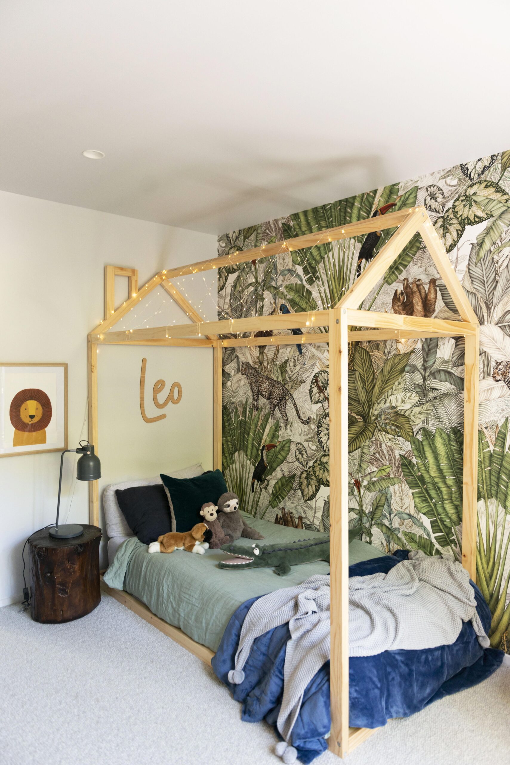 A Mocka cabin bed on the floor jungle wallpaper, and a large Leo sign is above the bed