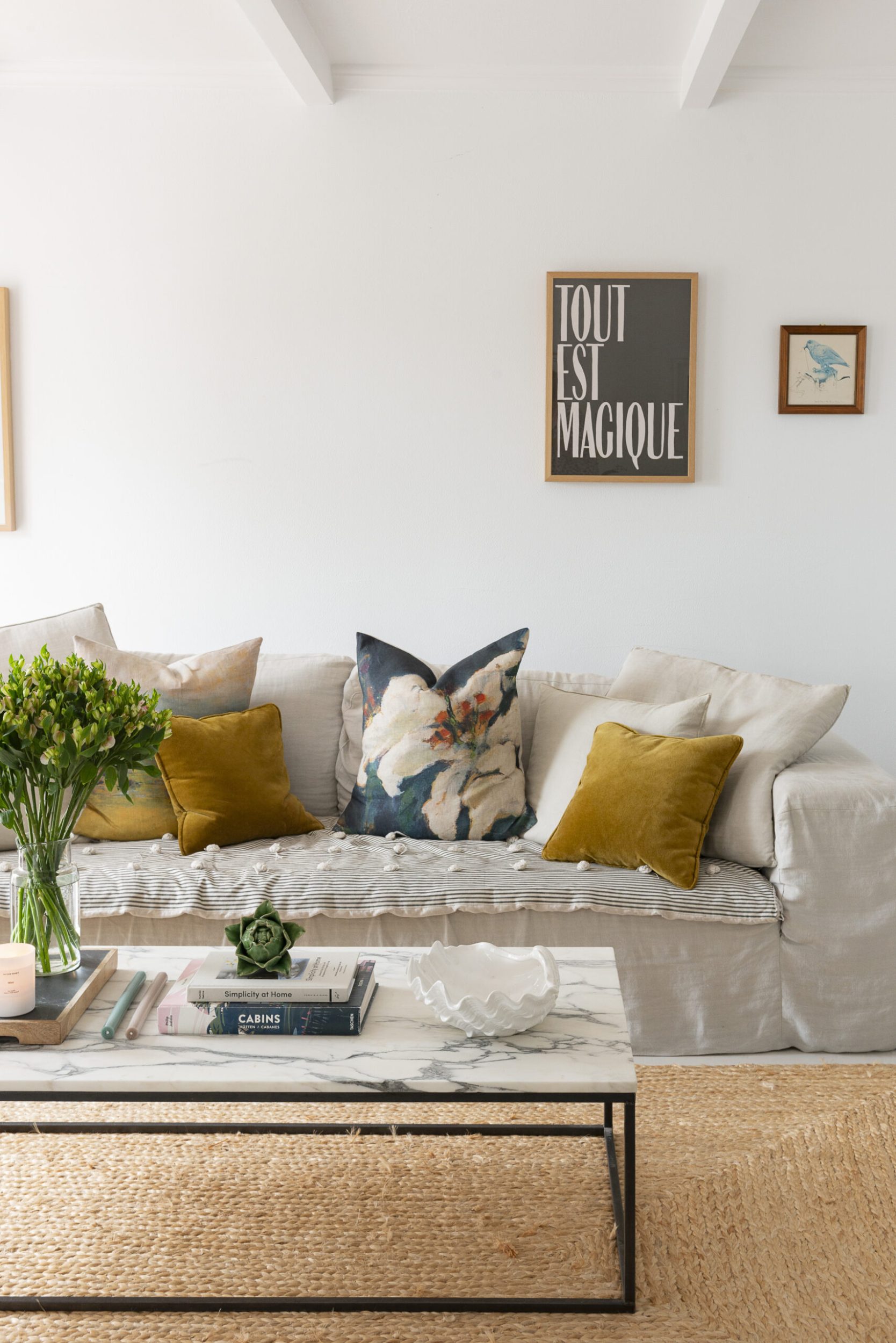 Claudia Zinzan's living room with sofa, coloured cushions and marble coffee table