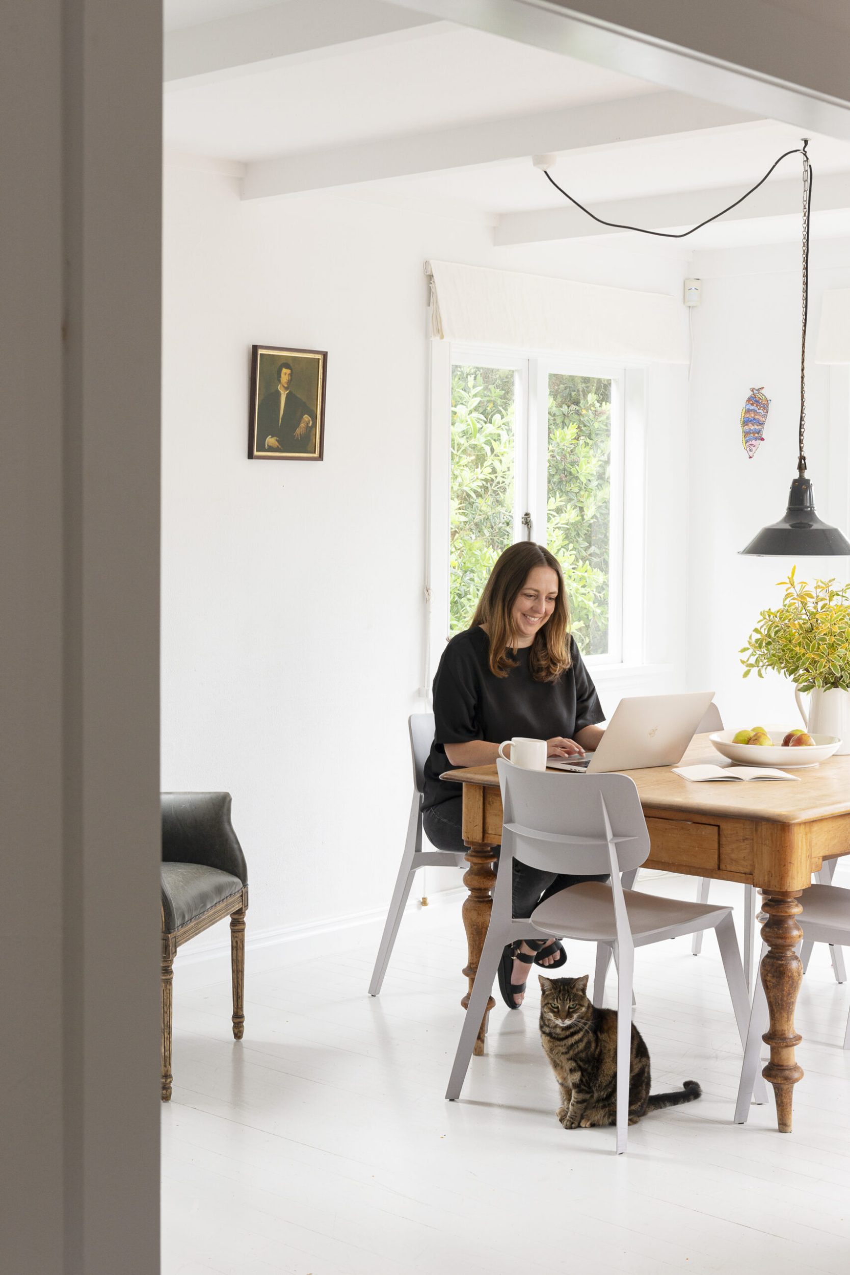 Claudia Zinzan sitting at her dining table working laptop