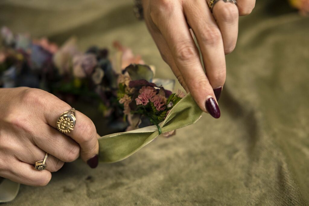 Threading green ribbon through wire flower crown