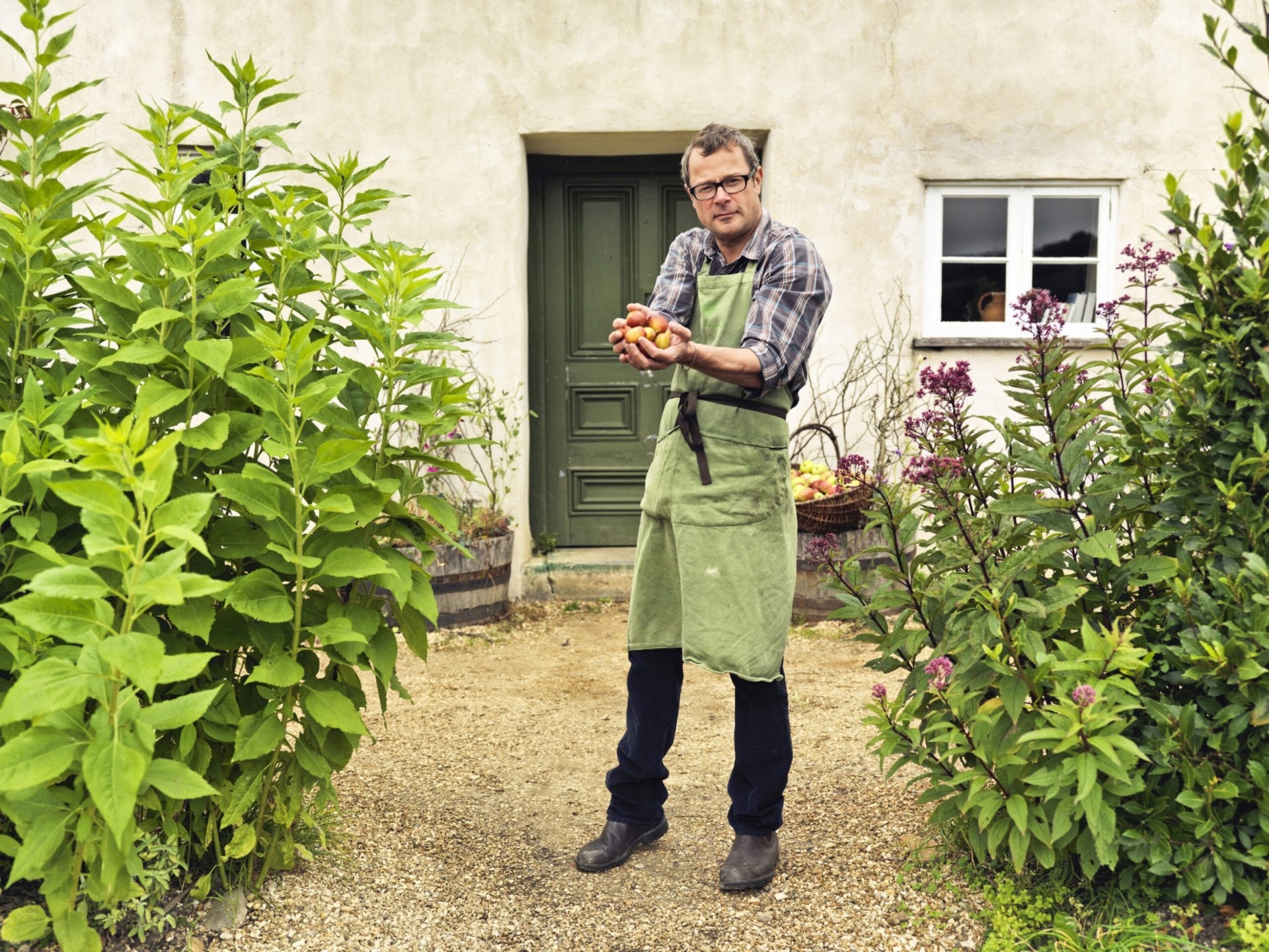 Hugh Fearnley-Whittingstall holding fruit in garden