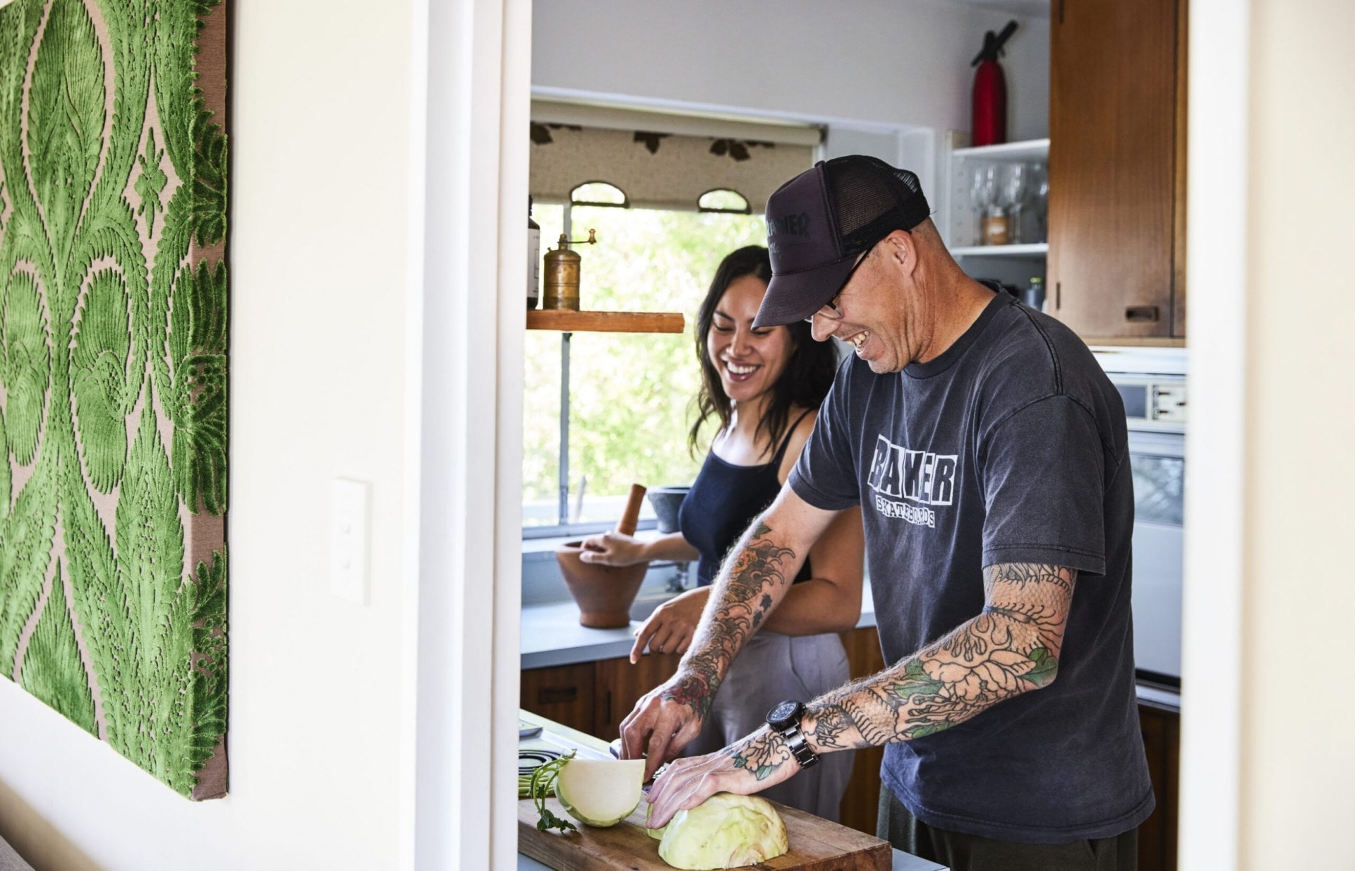 Olivia Orani and Che Barrington cooking in kitchen and laughing