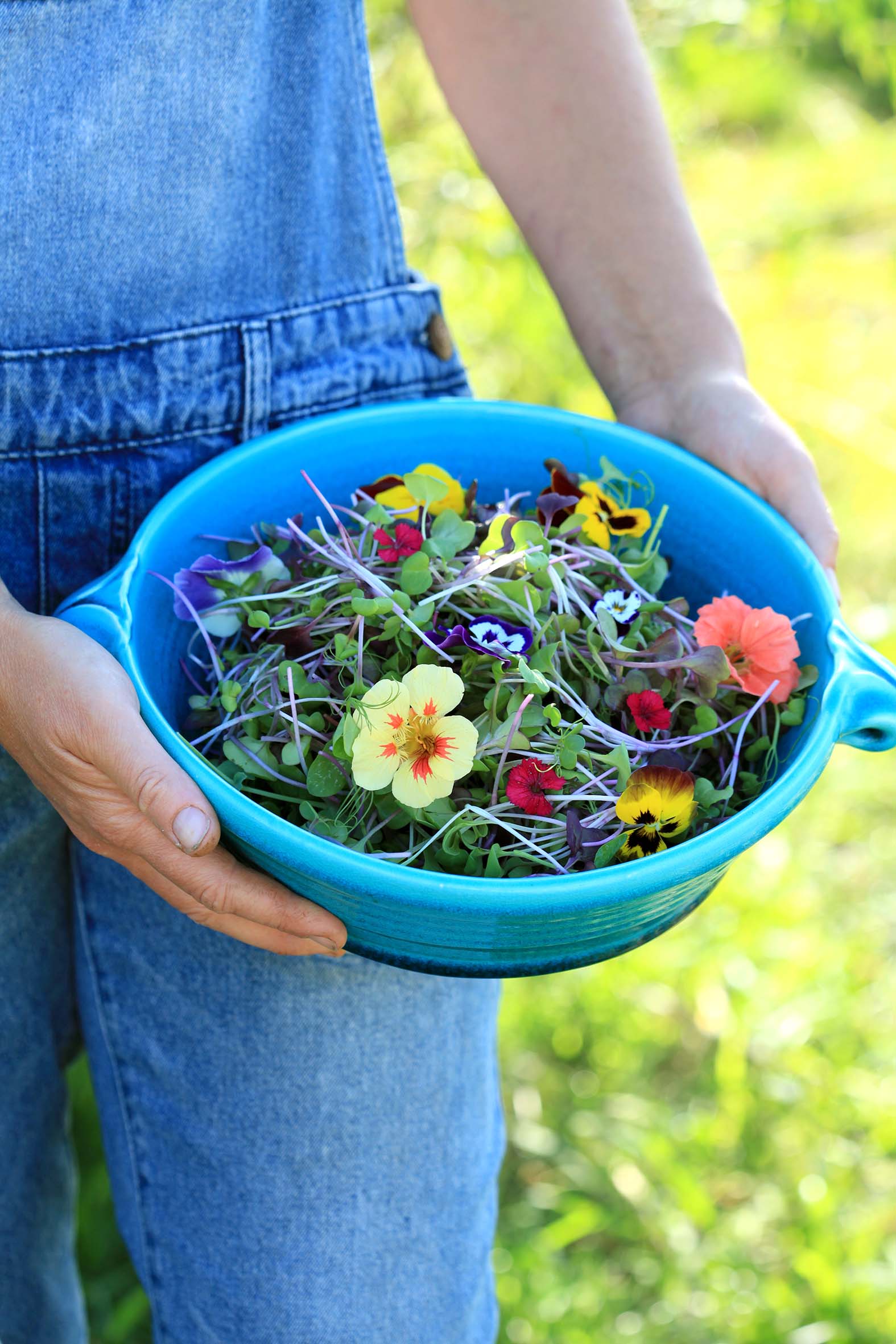 Woman holding a bowl of edible flowers