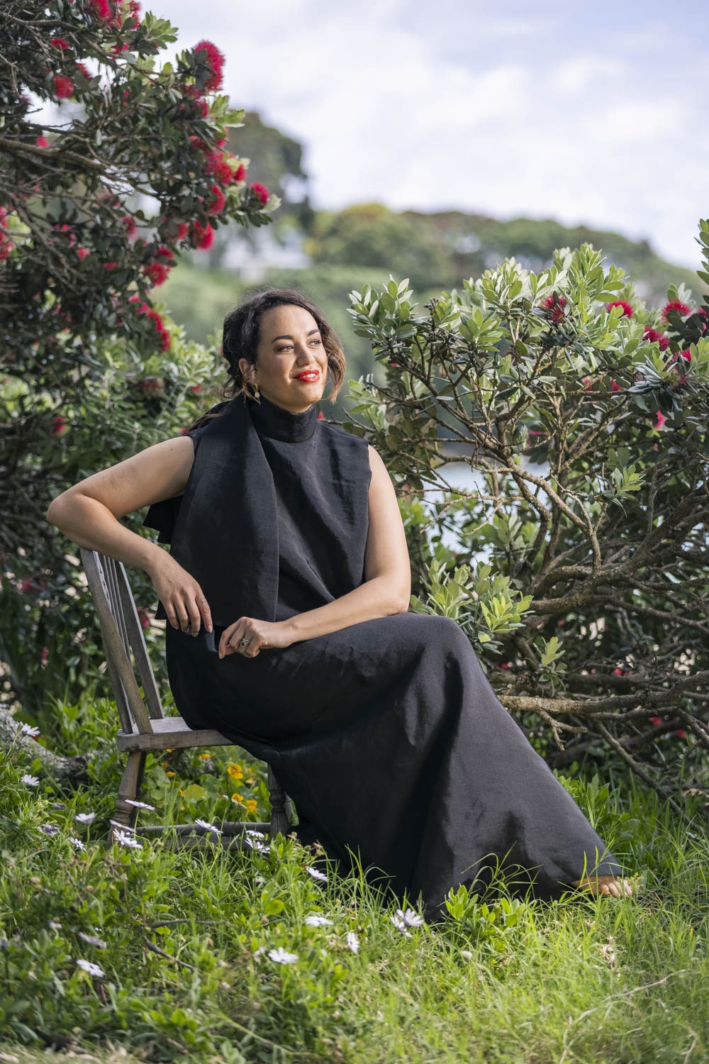 Kanoa Lloyd wearing black dress sitting by trees
