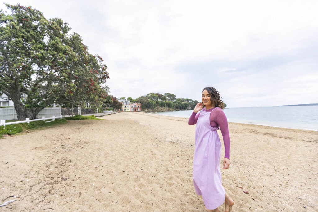 Kanoa Lloyd wearing lilac dress walking on beach