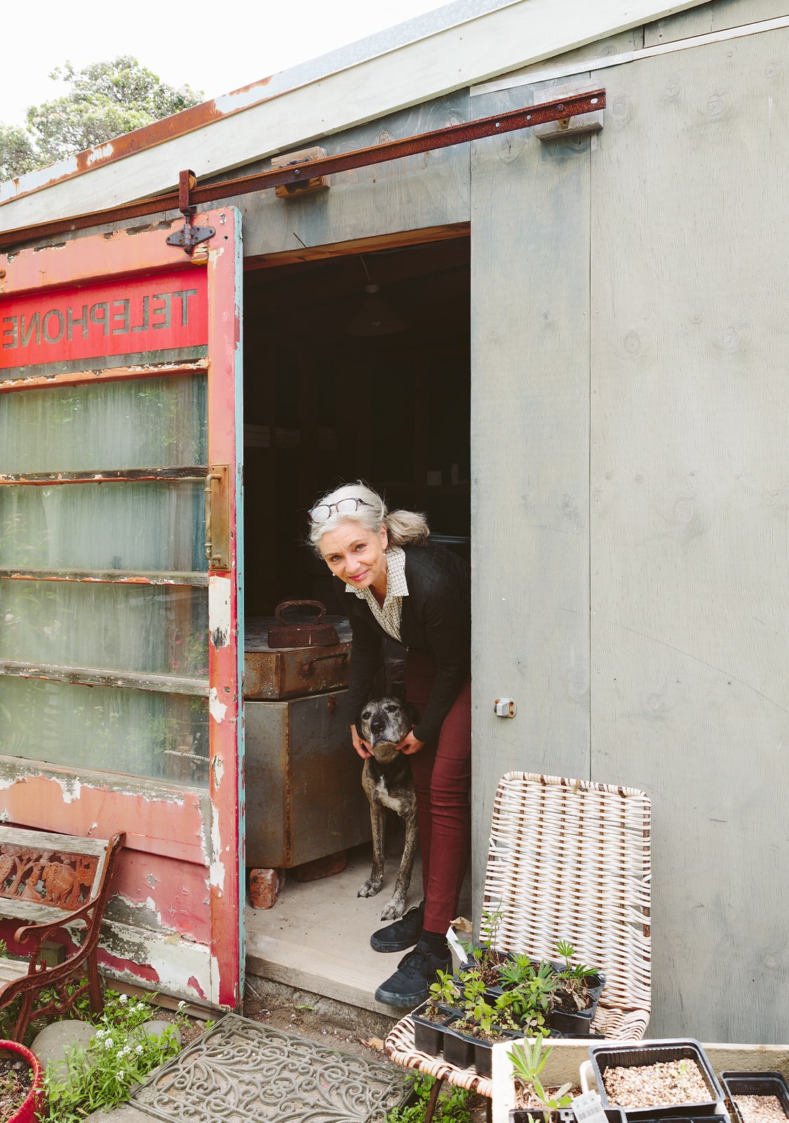 Kathryn Smythe looking out her pottery studio with dog Hadley