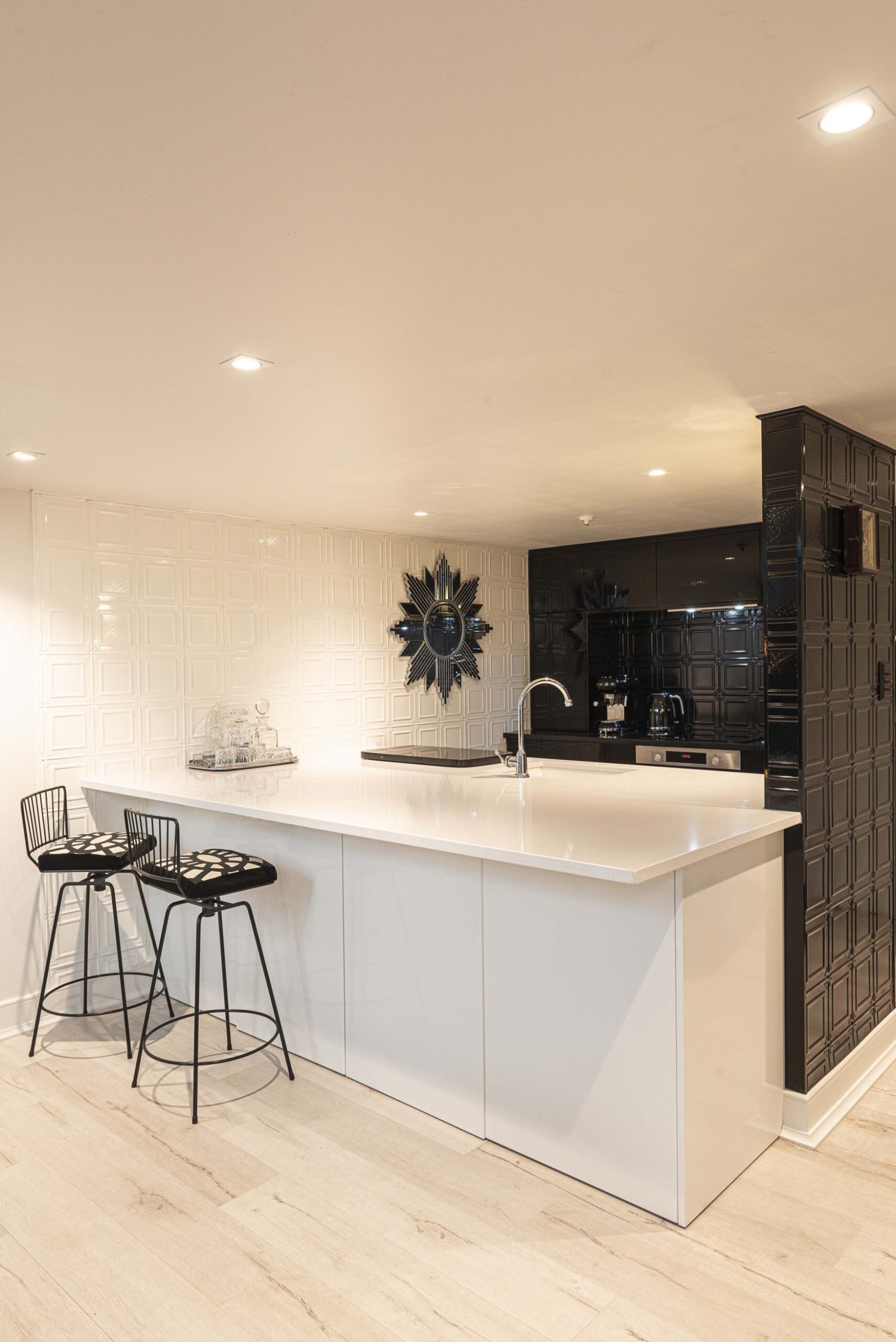 Kitchen with white pressed tin walls and black cabinetry