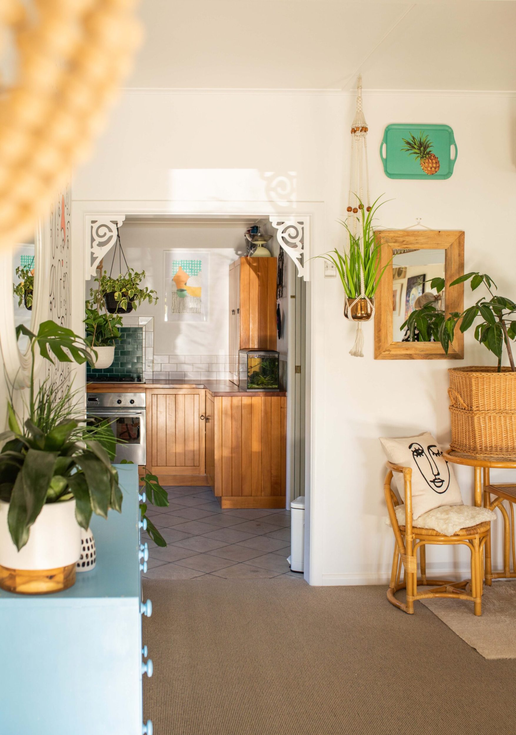 Hallway shot with a blue dresser on the left, kitchen in the background, and the dining room on the right 