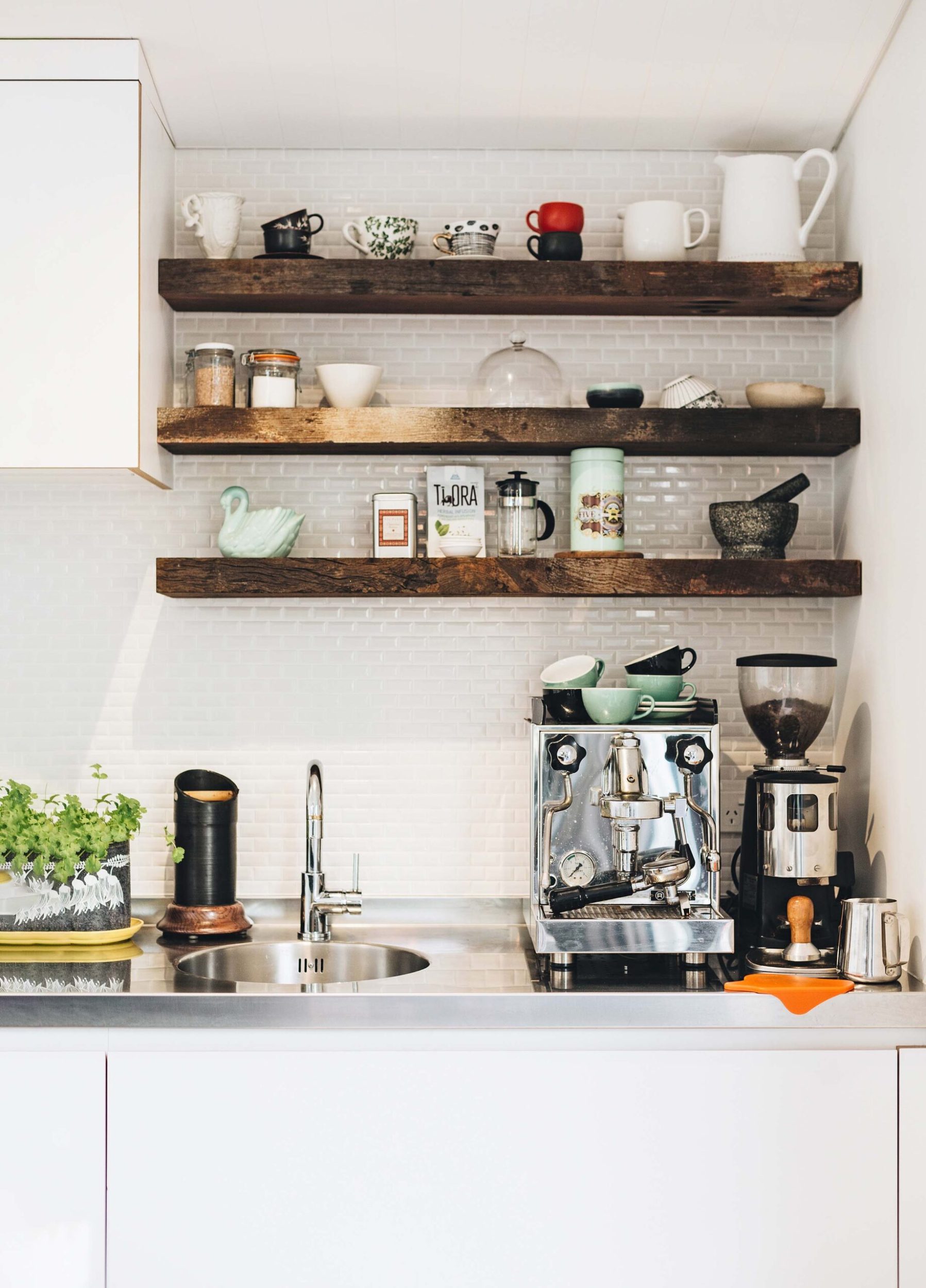 coffee bar with floating shelves, coffee machine and small sink