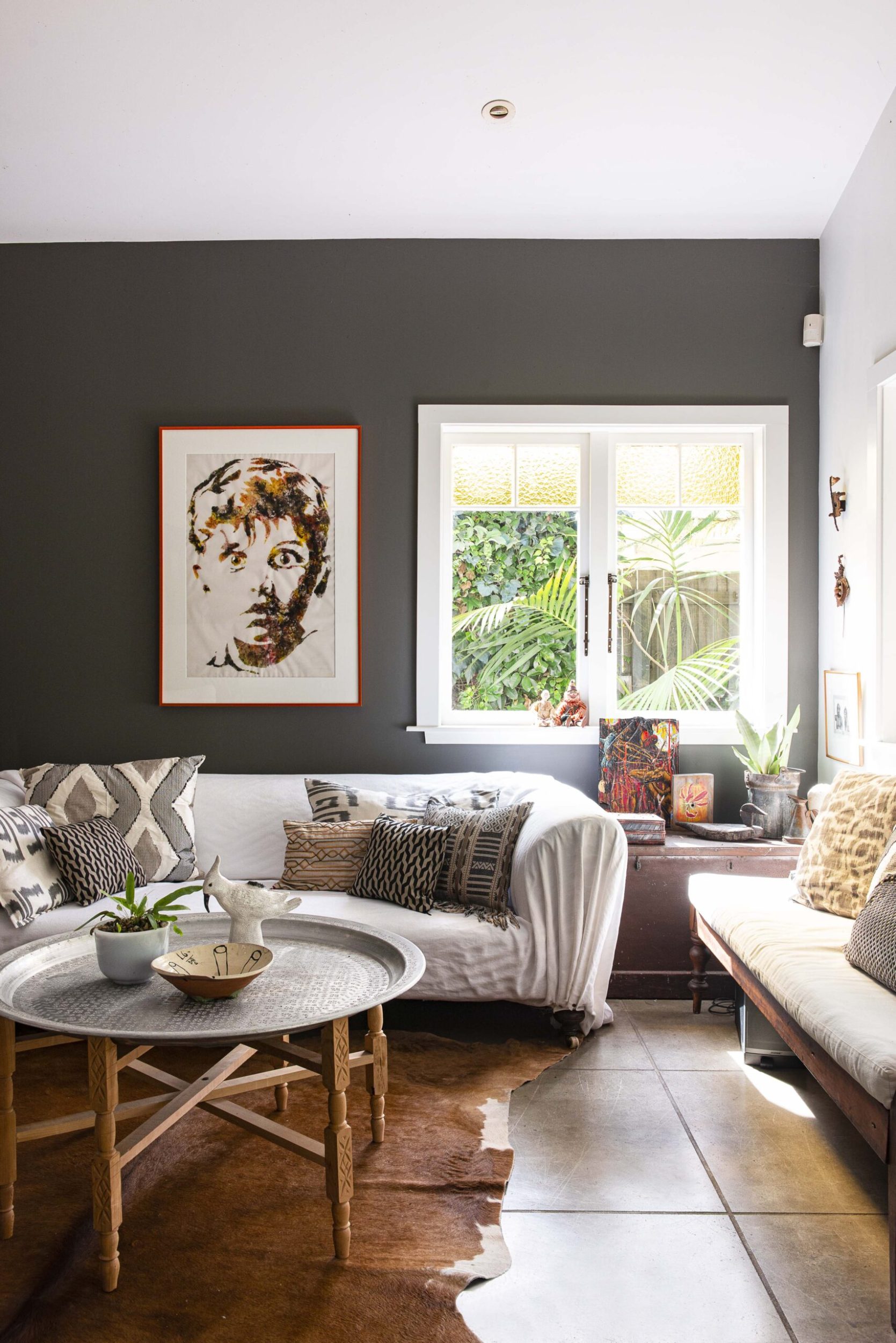 A black living room with a white couch with patterened pillows