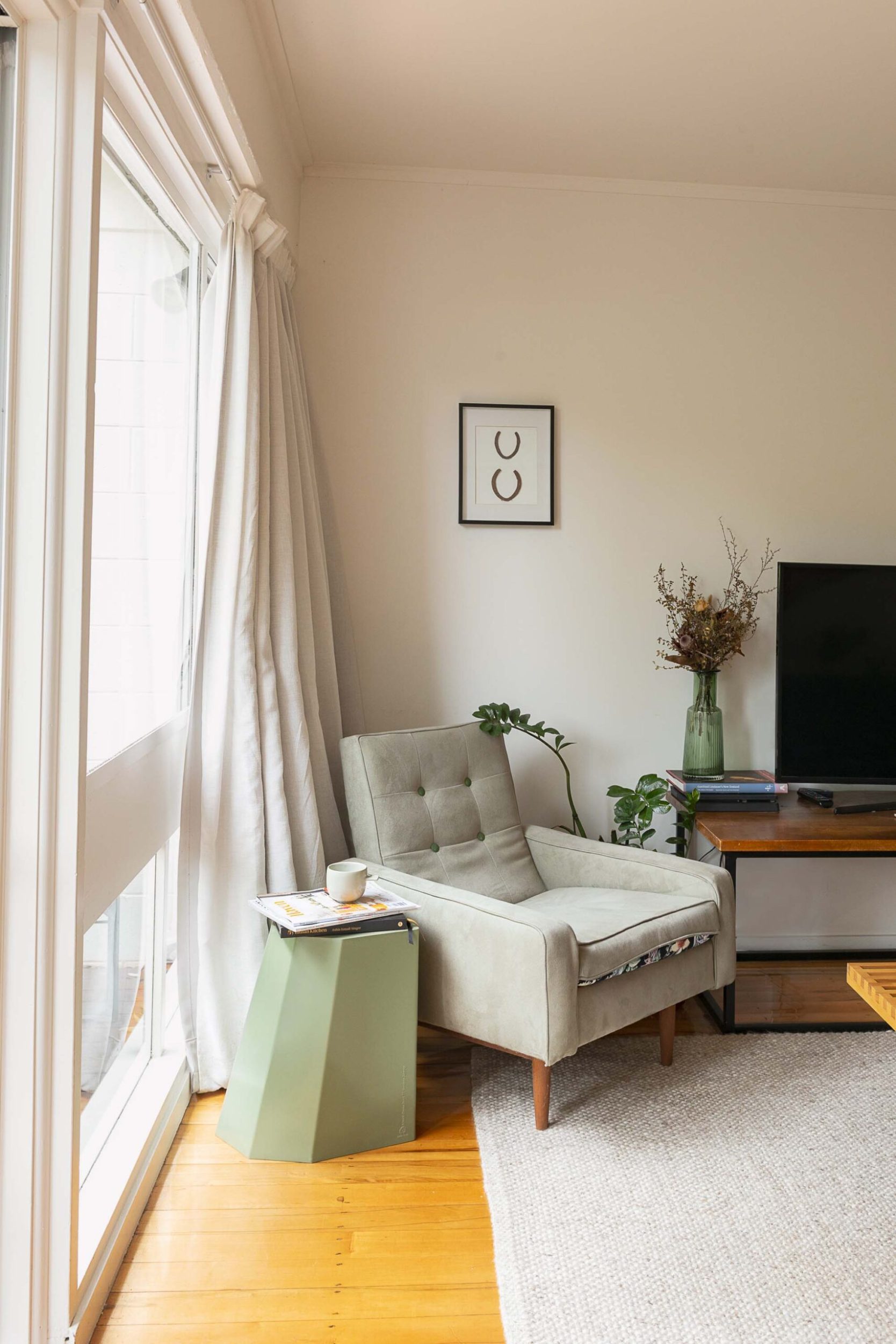 A grey chair in the corner of a living room