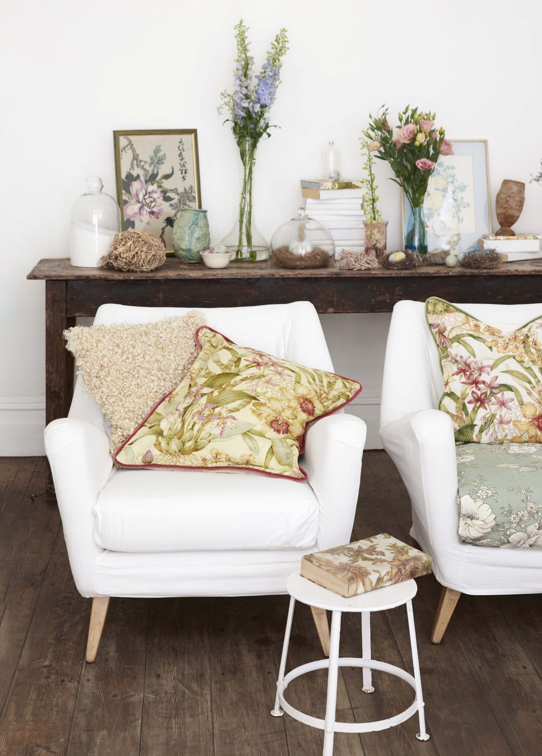 A white room with white chairs covered in patterned cushions