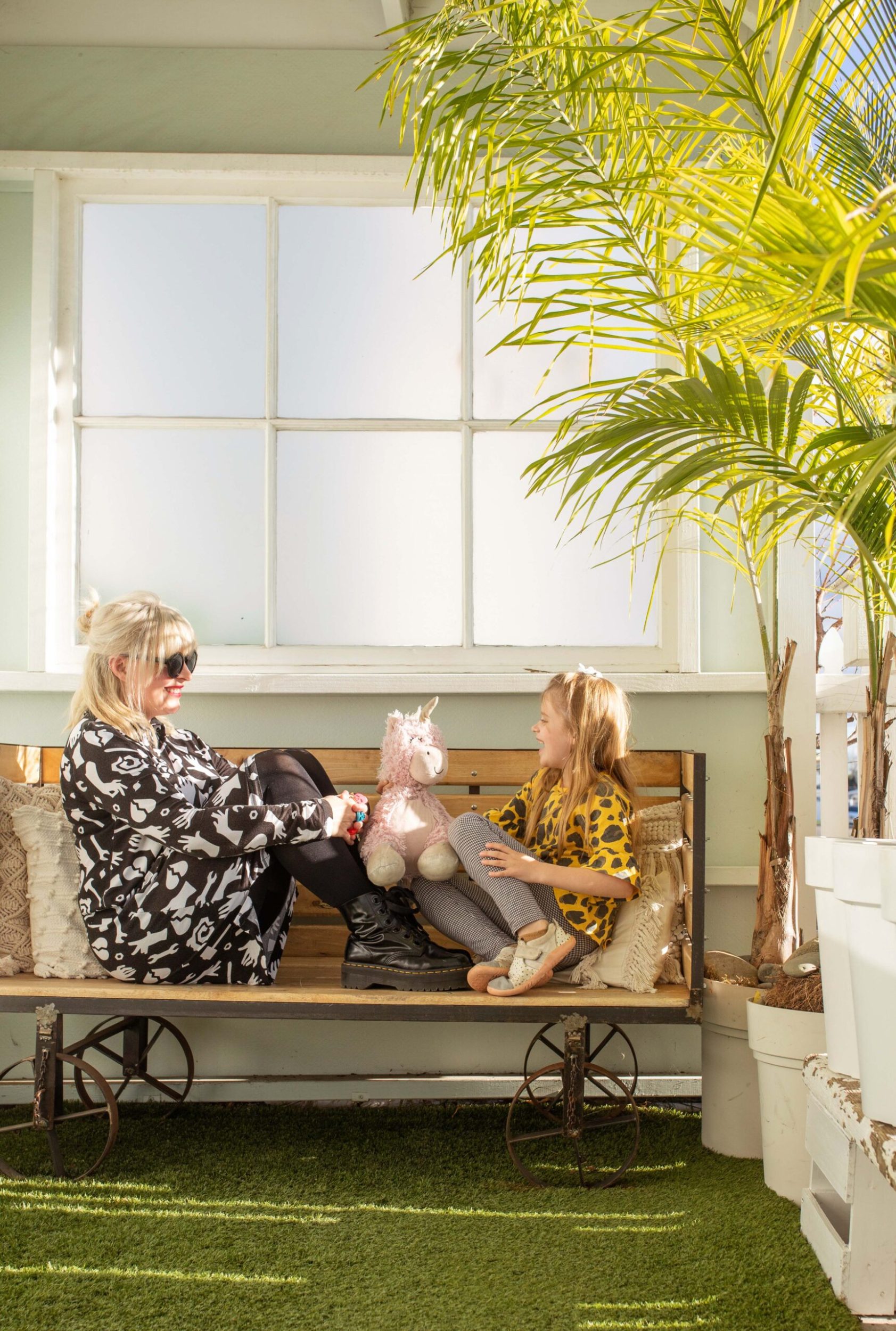 Rachael Stone and her daughter Juno sitting on a wooden bench inside their cottage