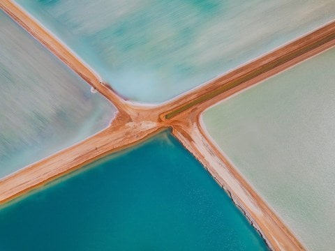 Aerial view of blue and green salt ponds in Western Australia