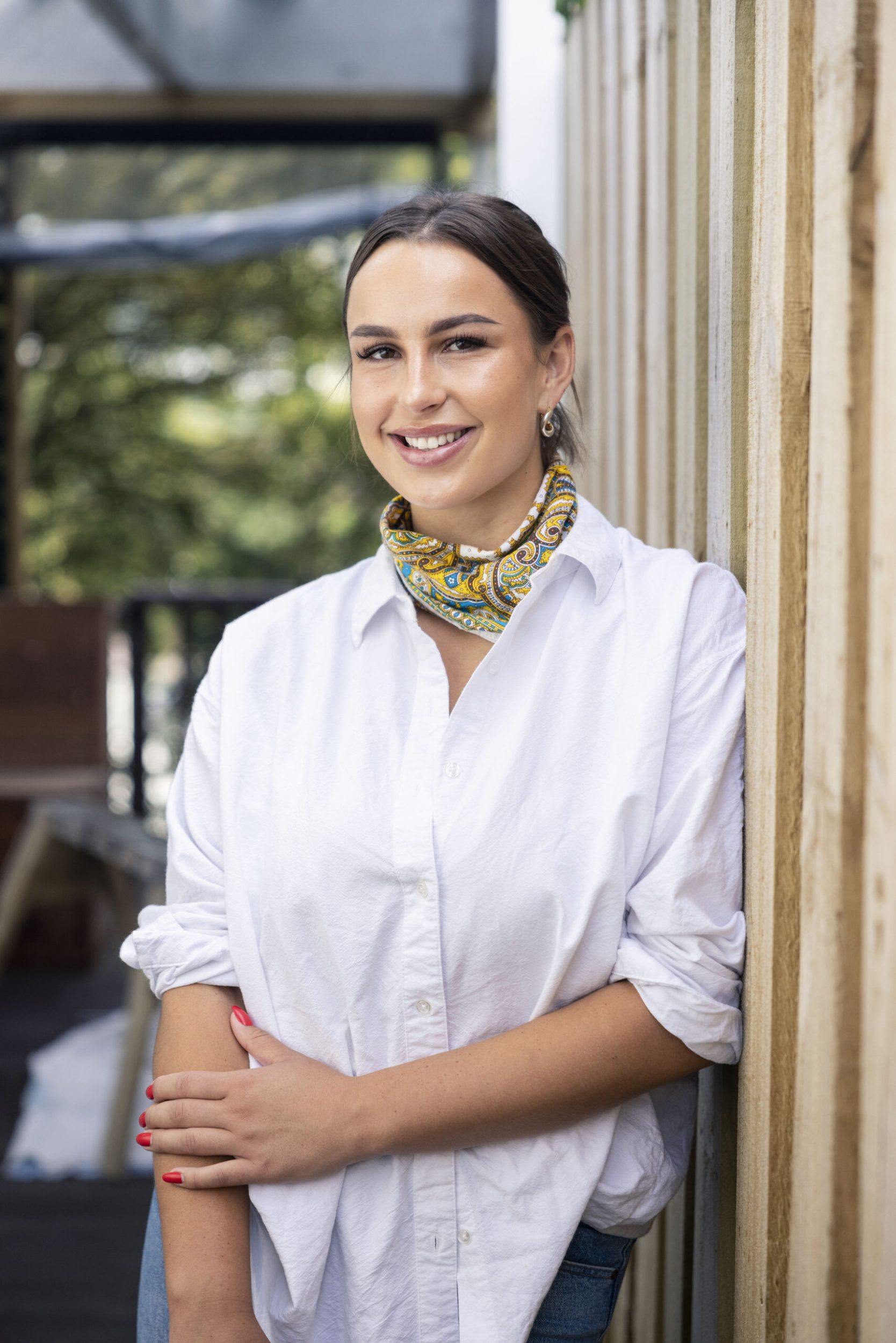 Zara Renton wearing white blouse and boho scarf around neck