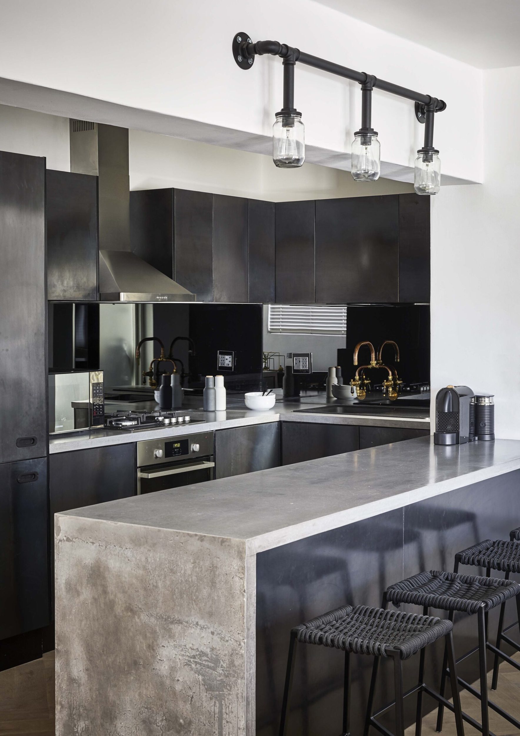 A black kitchen with grey marble benchtops