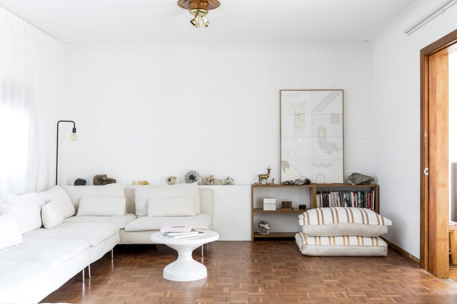 Living room with wooden floors, white walls and white couches 