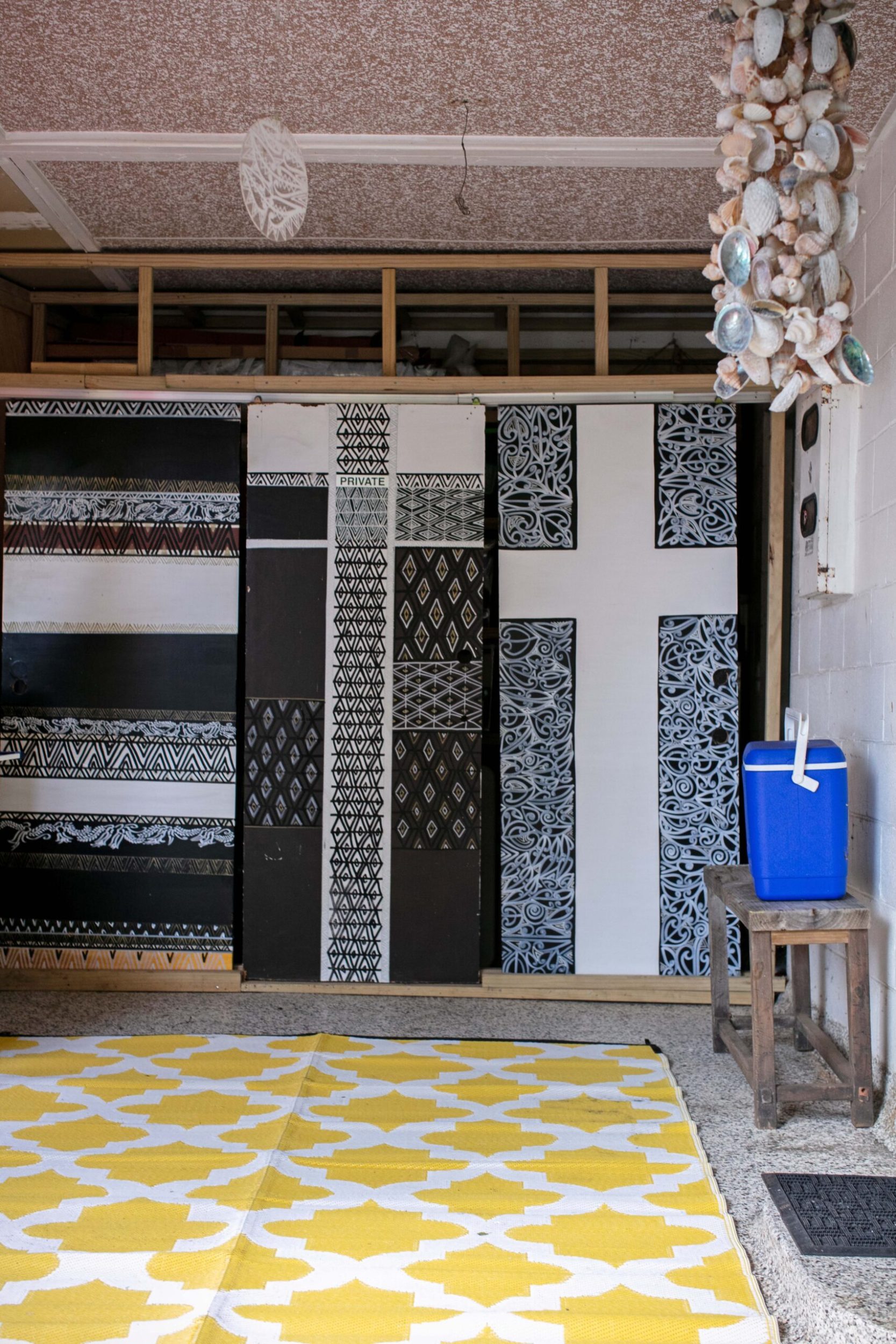 A double door wardrobe painted with black and white Māori art by Tracey Tawhiao