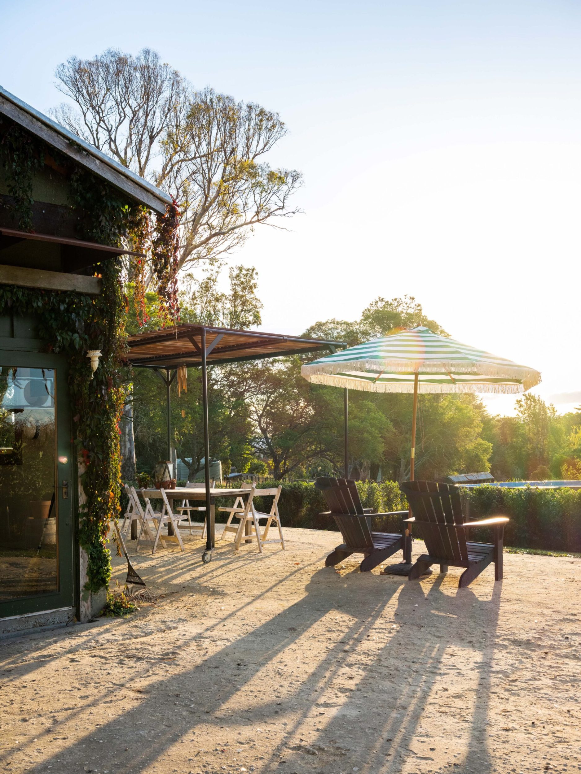 An outdoor area with two sun loungers and a large sun umbrella 