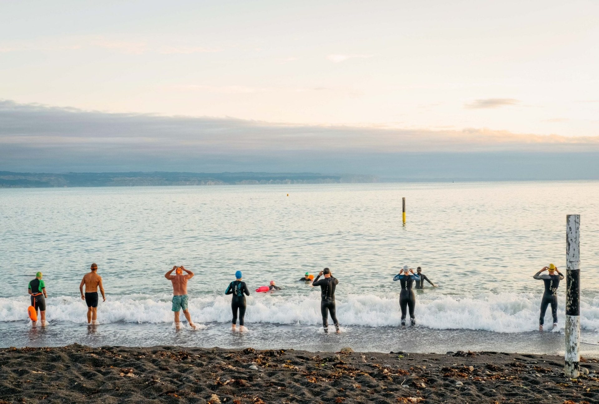 Swimmers preparing to swim at the edge of water
