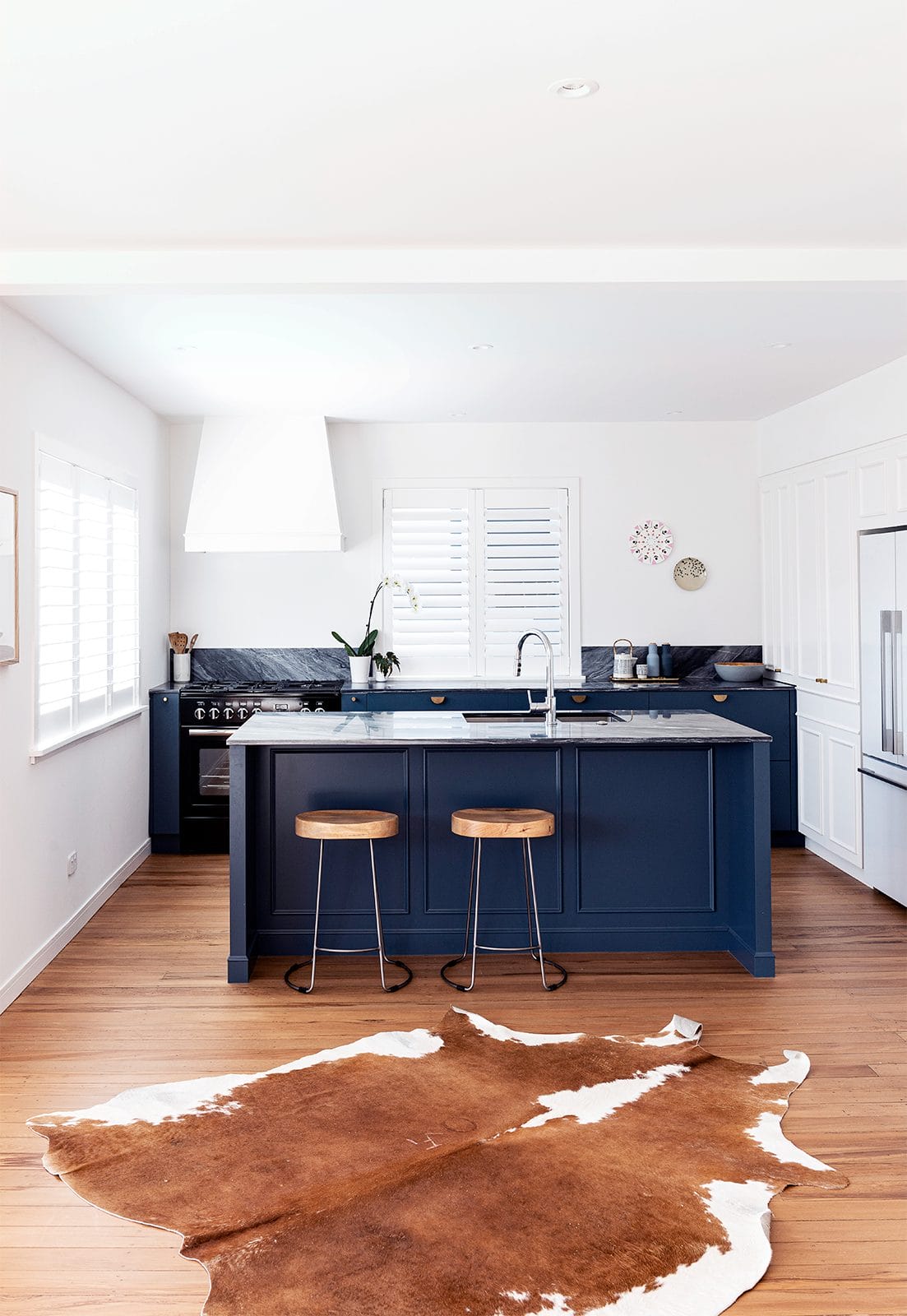 Kitchen with black kitchen island and brown cowhide on the floor