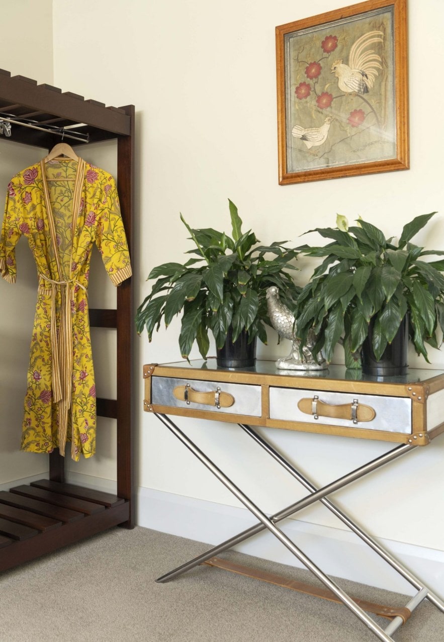 A hanging yellow robe and greenery on top of cabinet