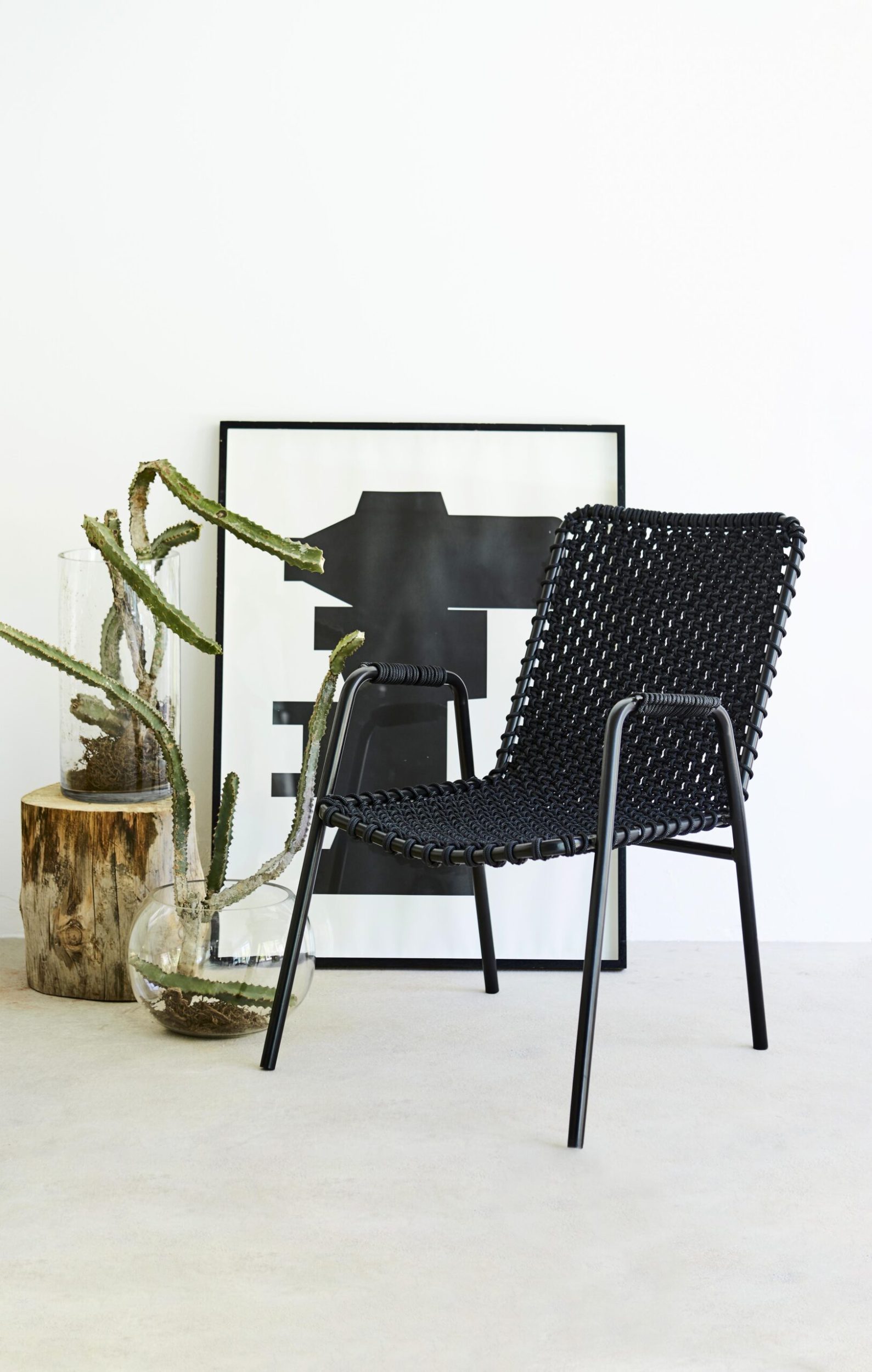 Black women chair with indoor plants and abstract black and white art 