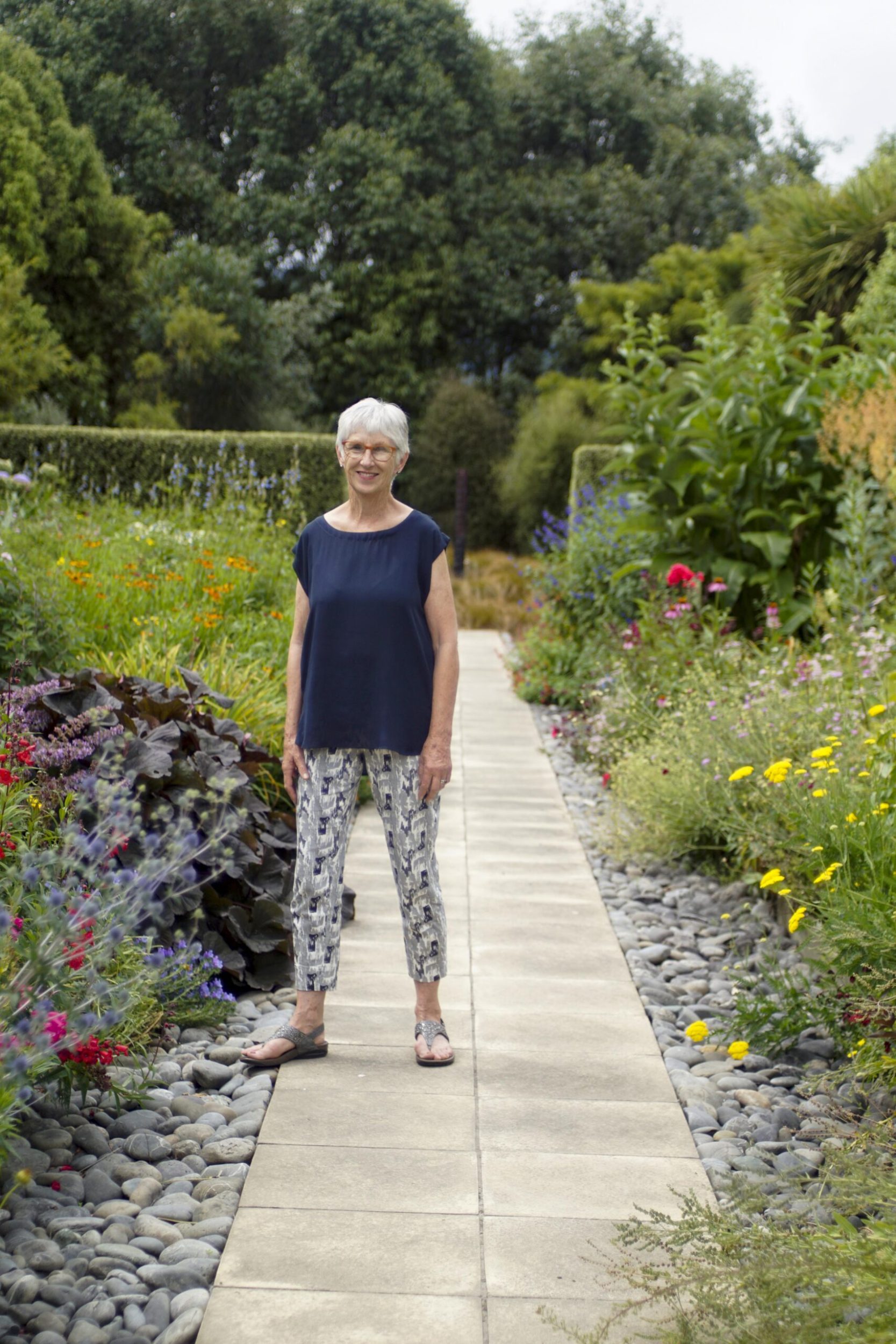 Rosanne Anderson standing on a wide stone path in a garden