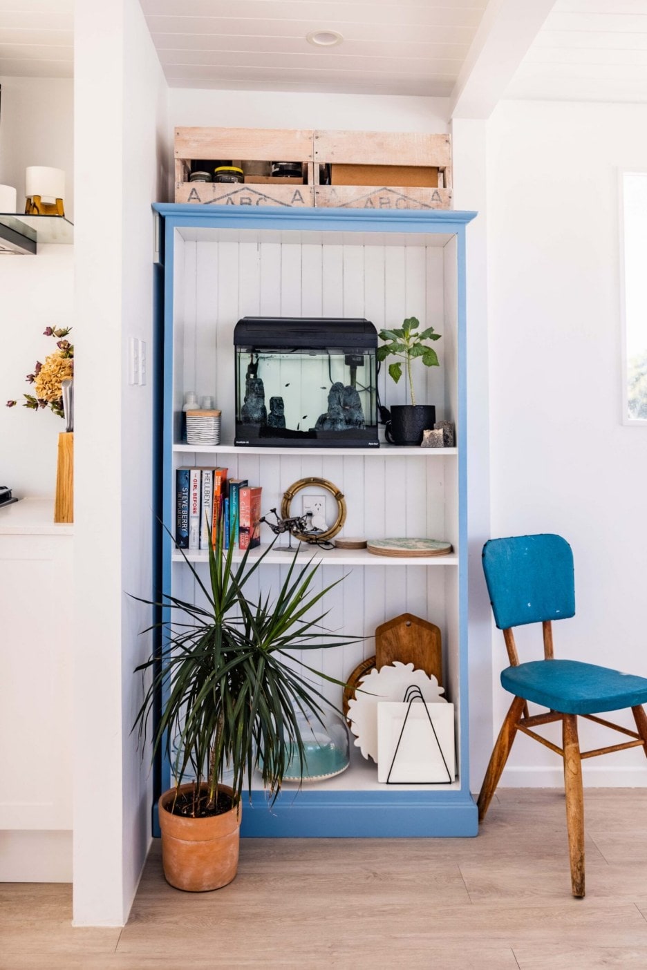 A blue and white shelf next to a blue chair