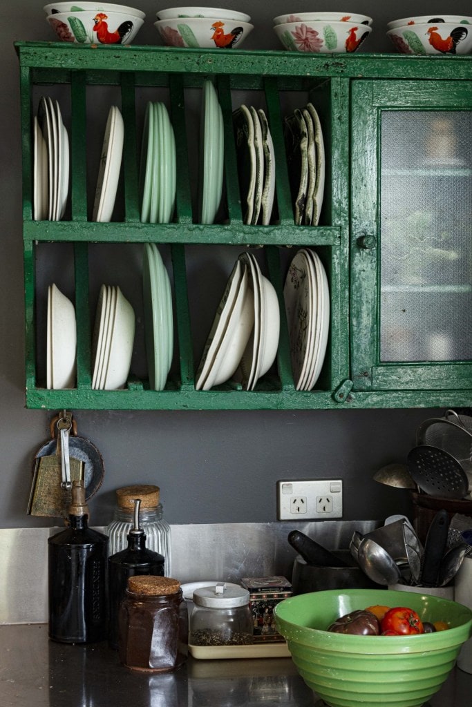 A black wall with a green shelving space