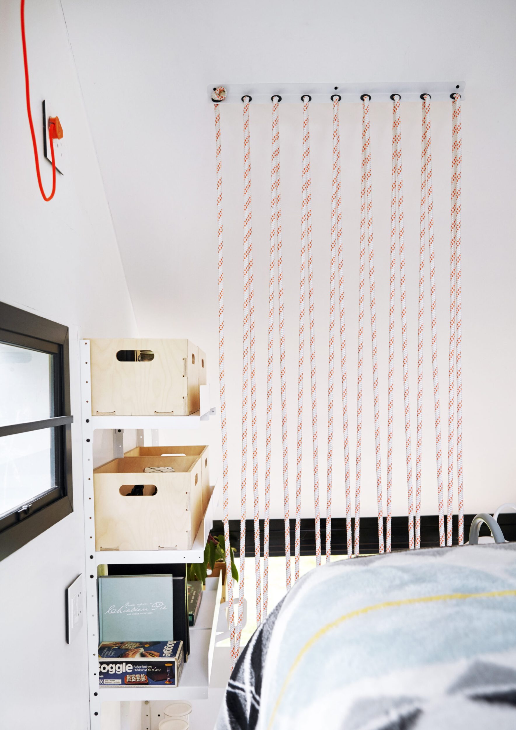 A small bedroom with a hanging electrical cord 