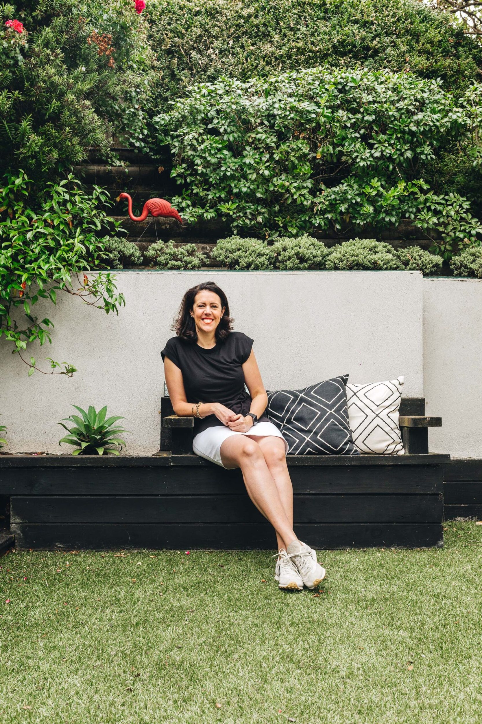 Sarah Meikle sitting on a garden on a black bench