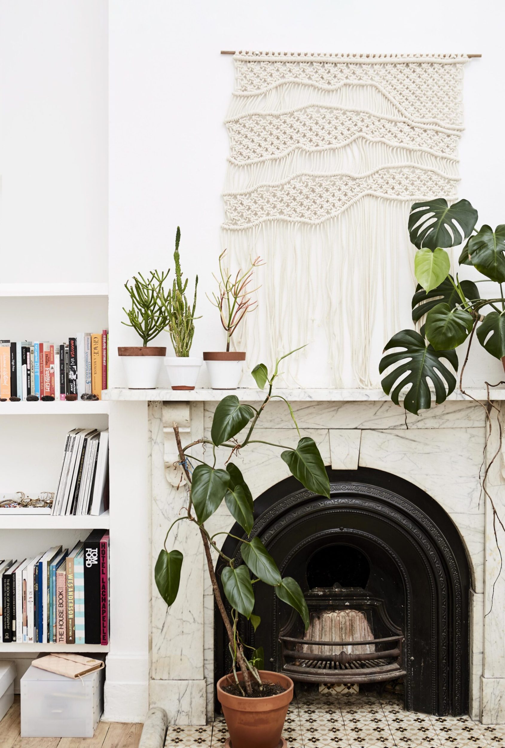 Fireplace with macramé wall tapestry hanging above it