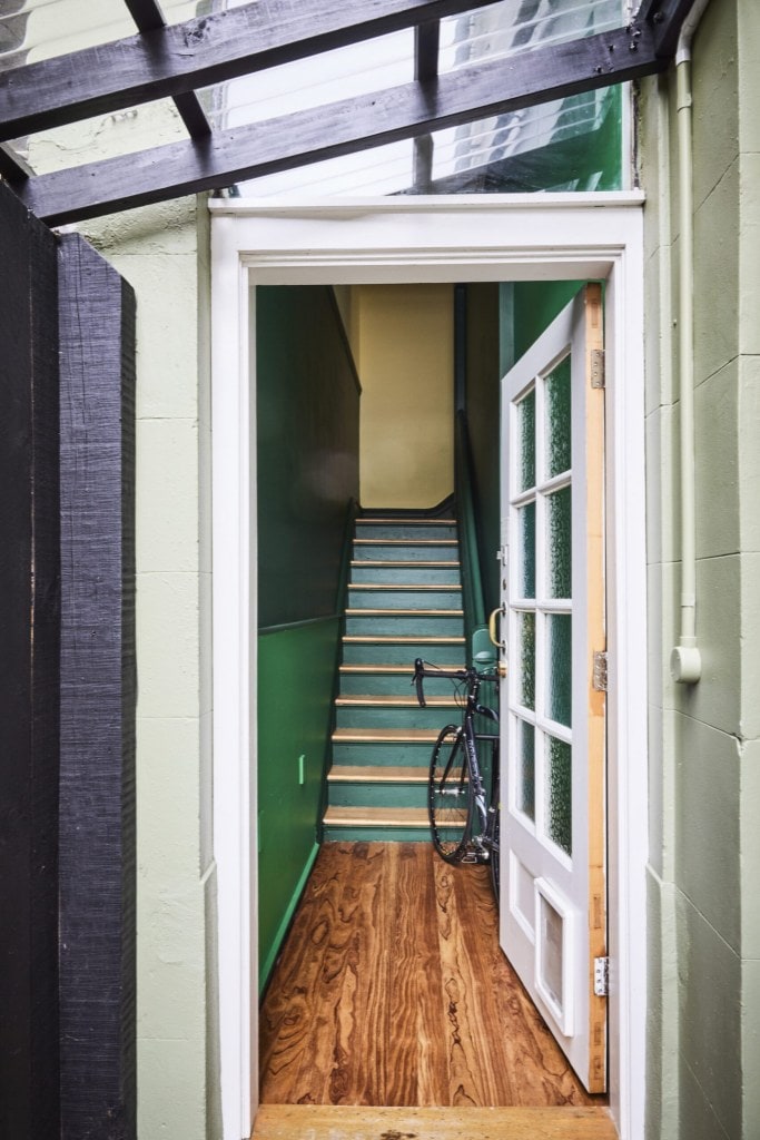 A green staircase on top of wood floors 
