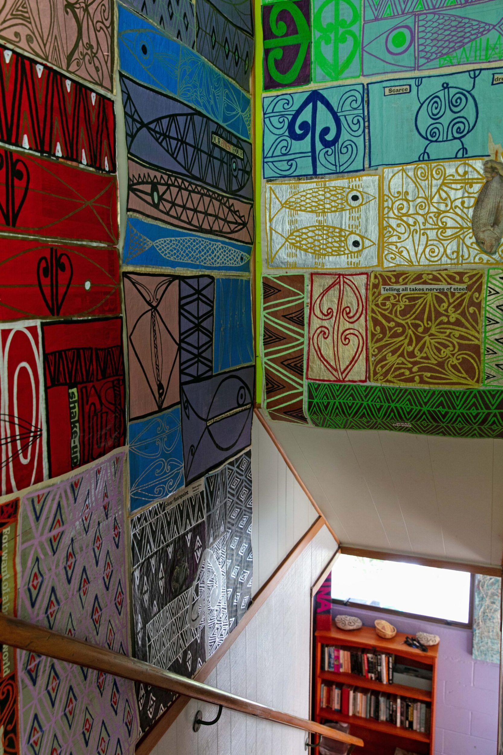 A stairway with walls decorated by Māori art by Tracey Tawhiao