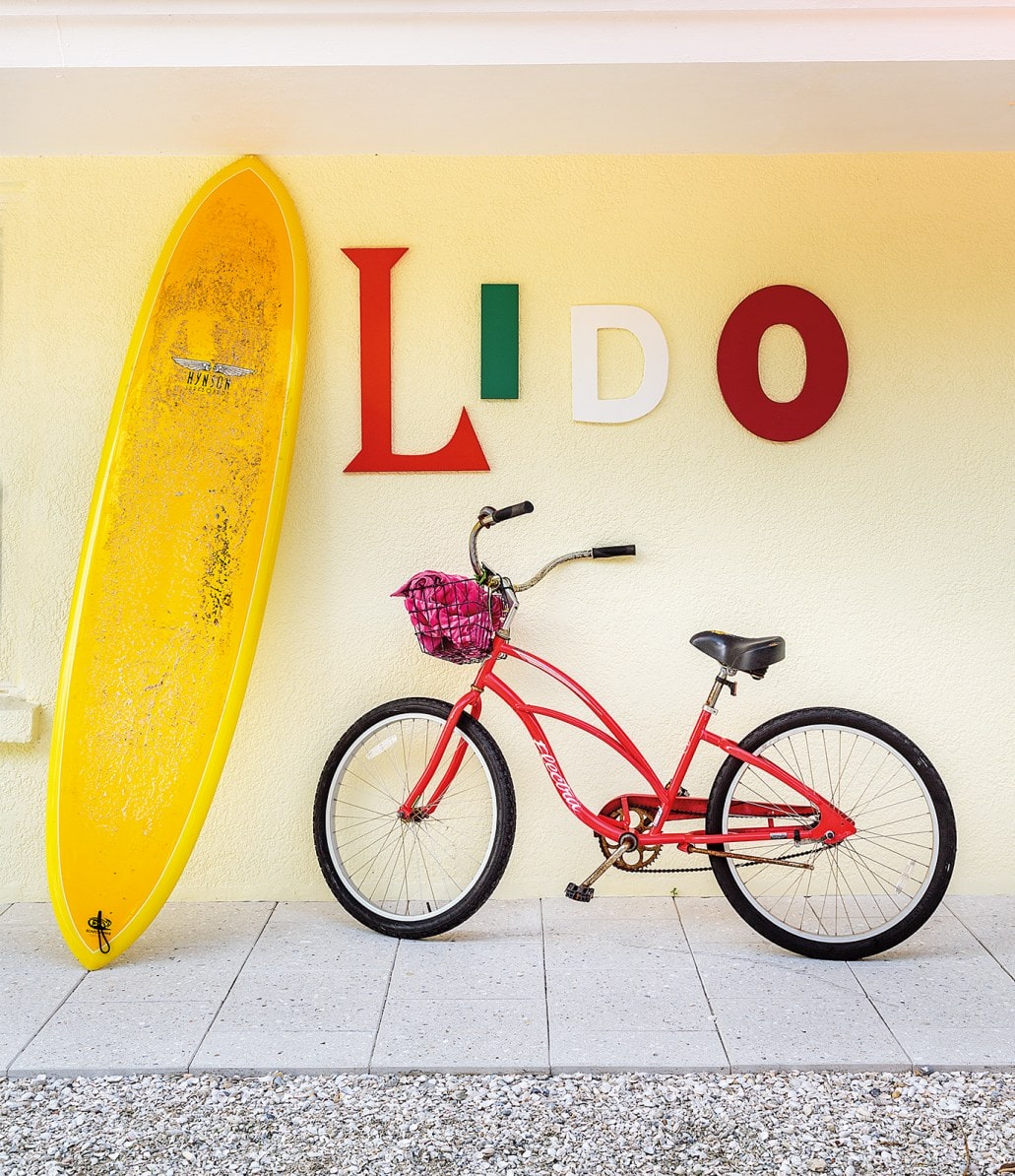 Outside area with decorative bike, surfboard and letters 