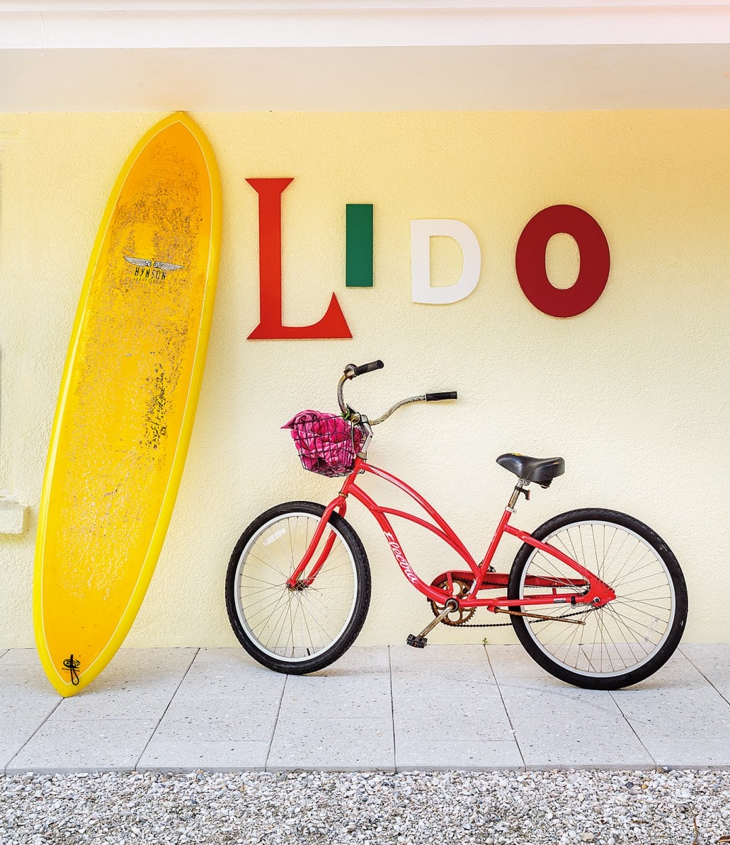 Outside area with decorative bike, surfboard and letters