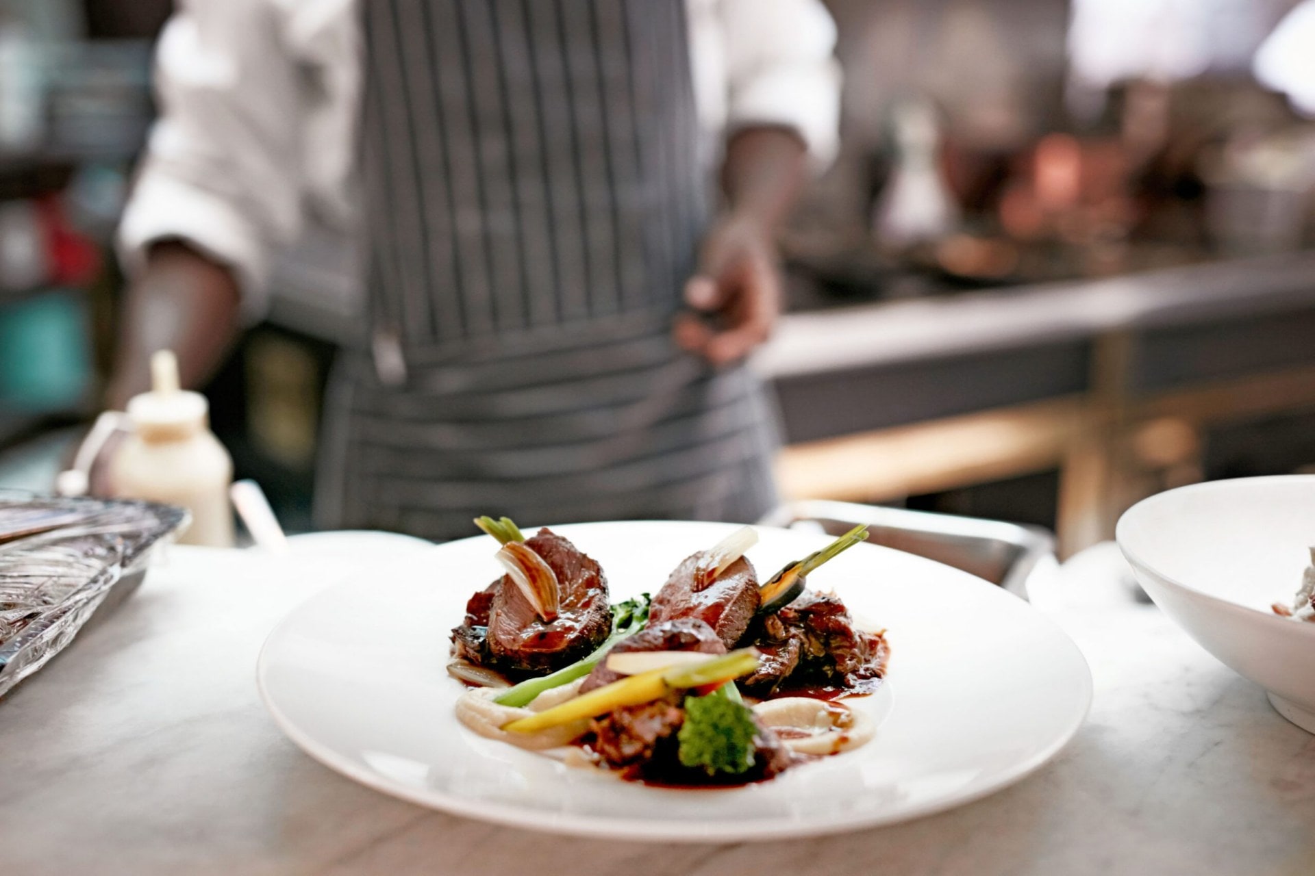 Restaurant mushroom dish next to man in grey striped apron