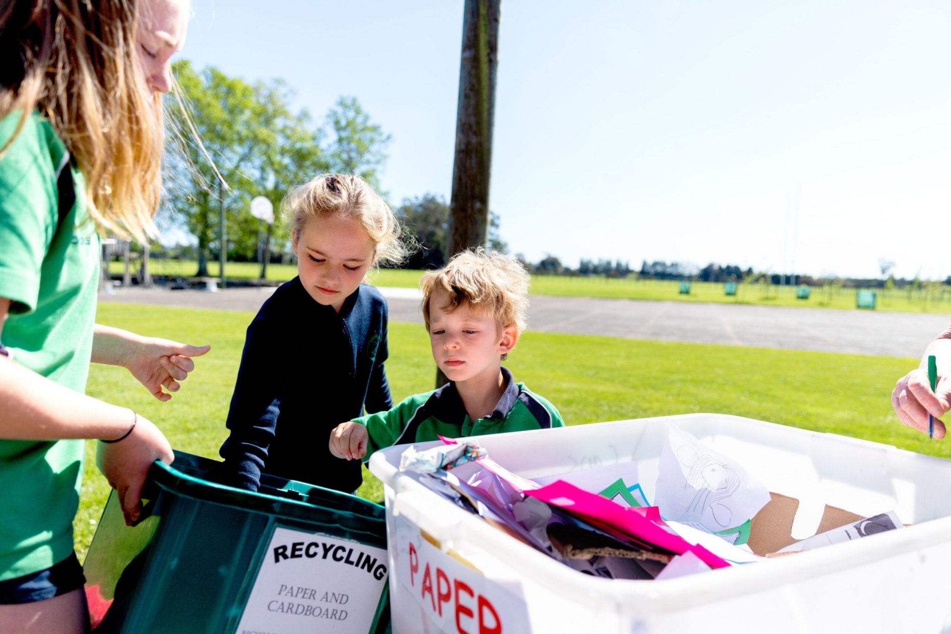 Three children sorting recycling waste.