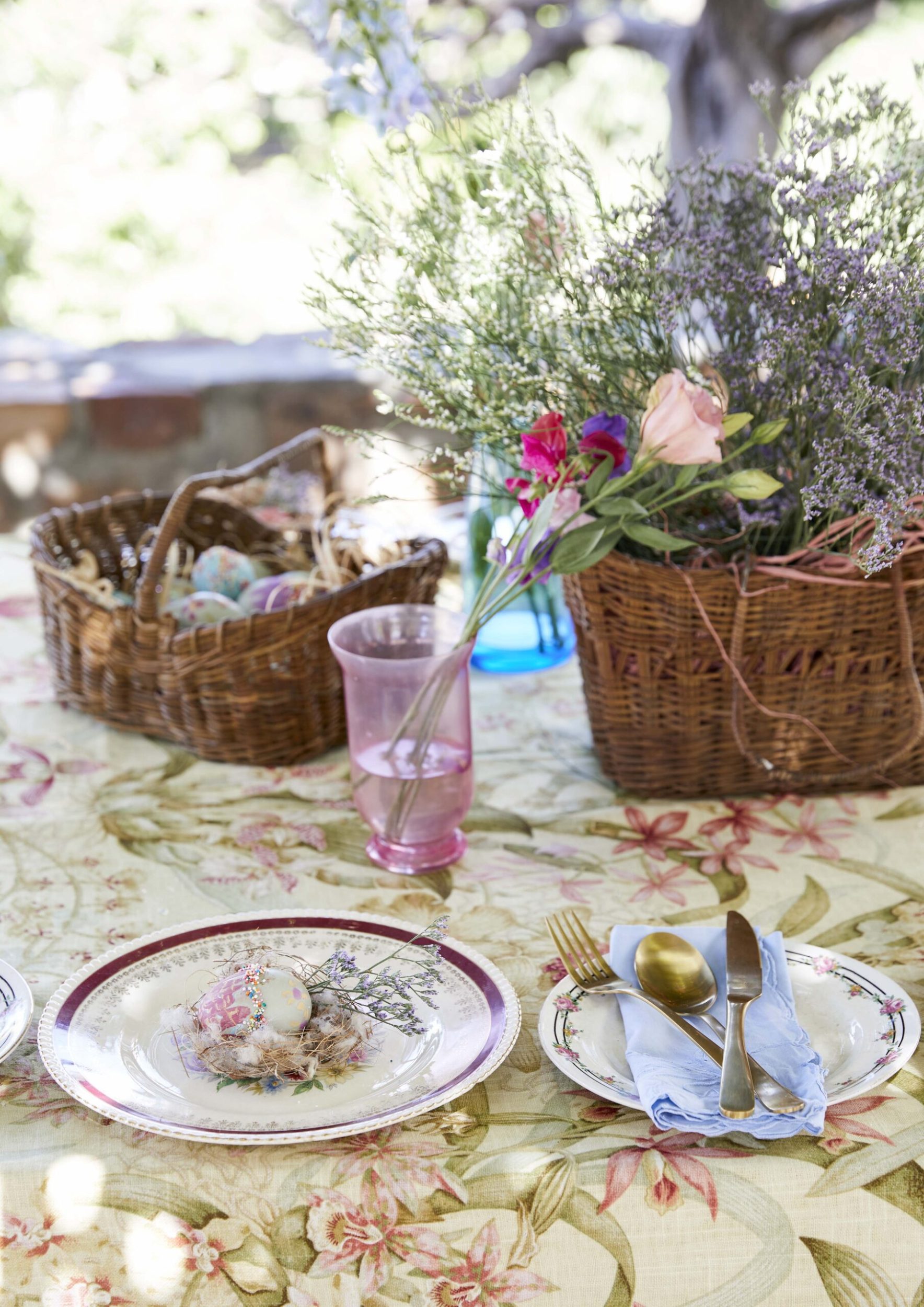 A table with a floral table spread and assorted Easter items